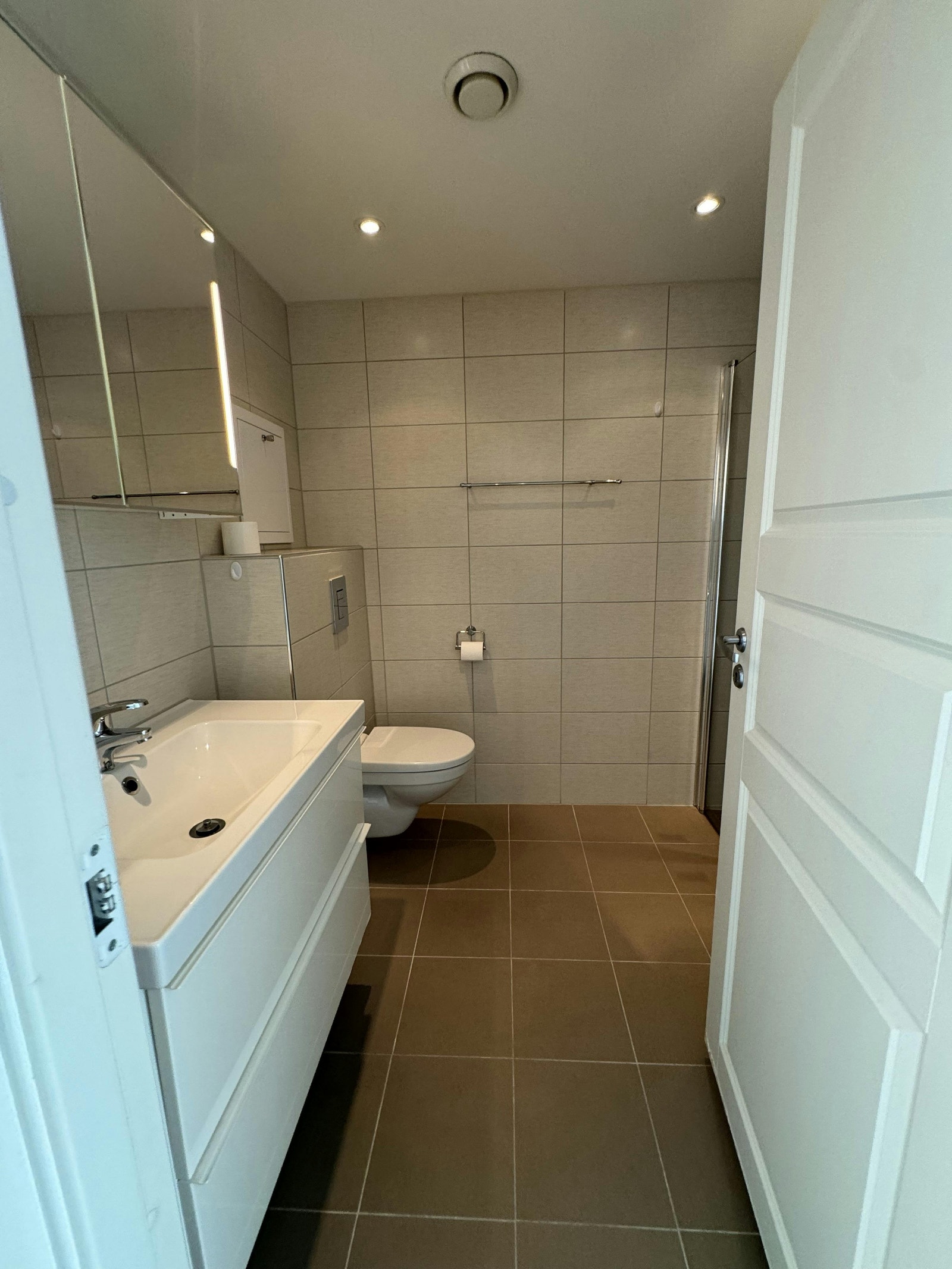 Moderne flislagt bad med opplegg for vaskemaskin og tørketrommel Galleribilde