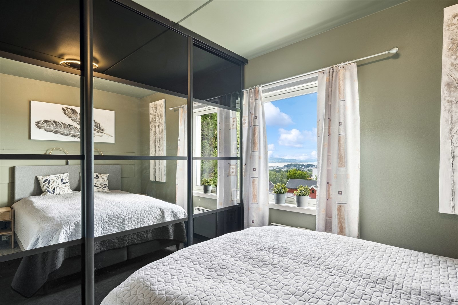 Det er satt inn en romslig skyvedørsgarderobe med speilfronter Galleribilde