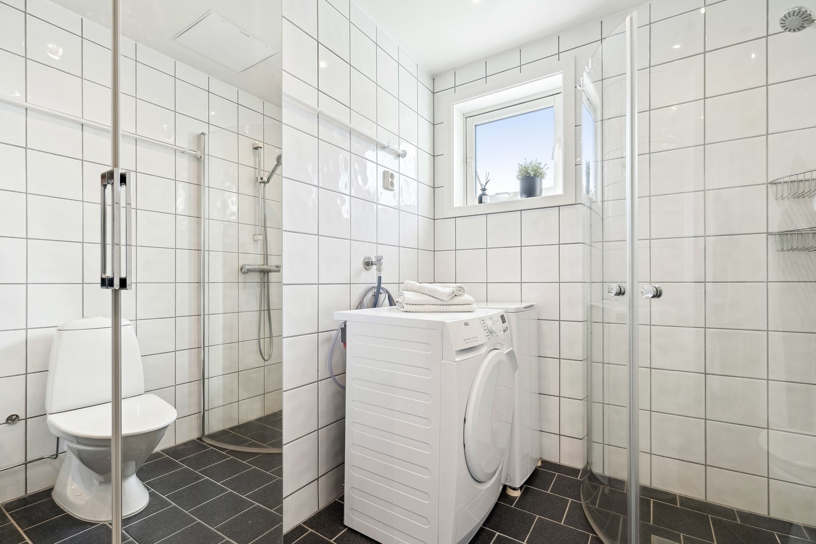 Romslig flislagt bad på 5,5 kvm. utstyrt med blant annet gulvvarme og opplegg for vaskemaskin Galleribilde