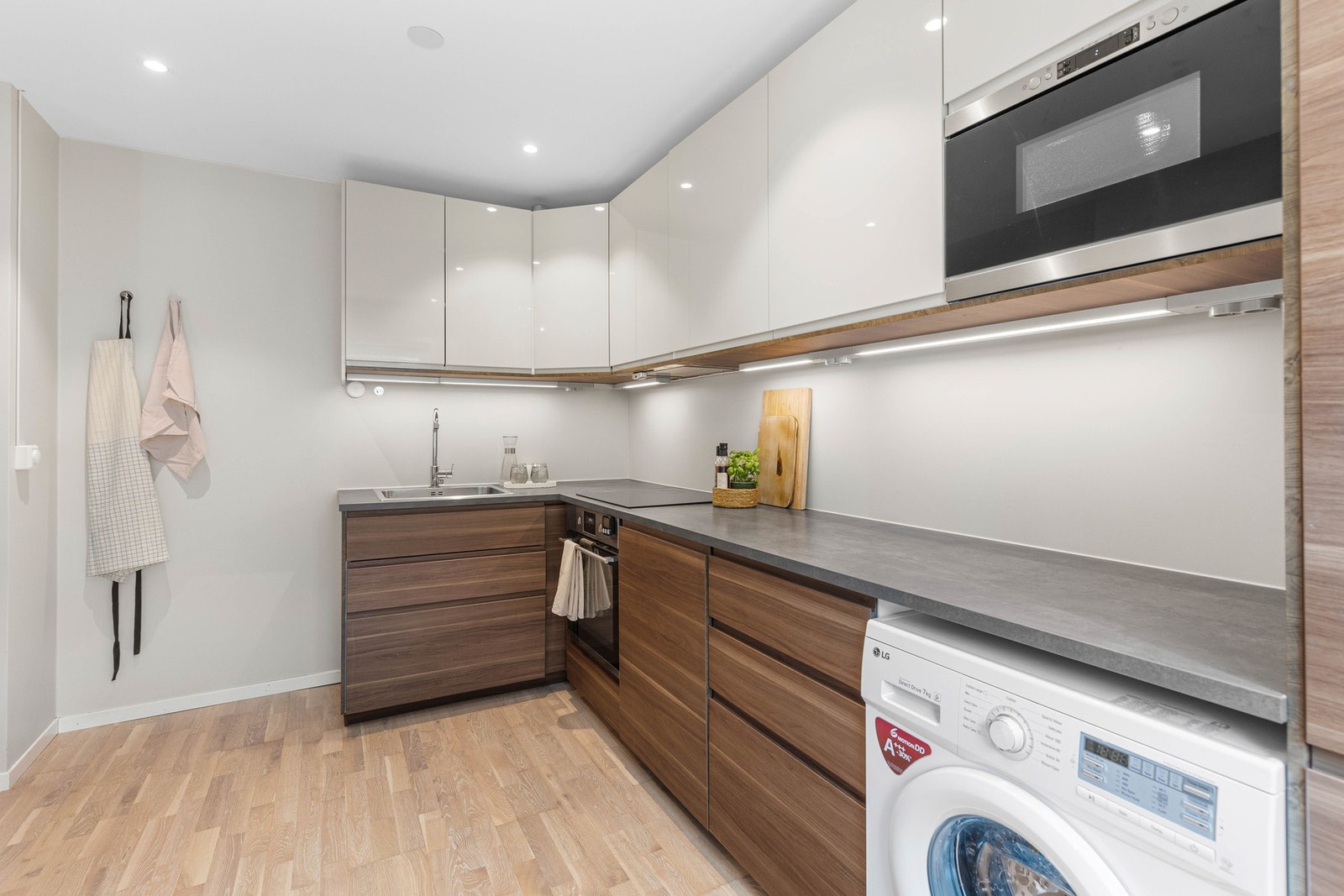 Moderne kjøkkeninnredning som står godt i stil med resten av leiligheten, samt god belysning fra downlights i tak, og led-striper under overskap. Galleribilde