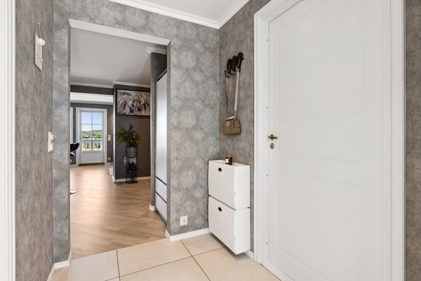 Velkommen inn - her ønskes du velkommen inn i lys entrè med plass til å henge fra deg ytterklær. Galleribilde