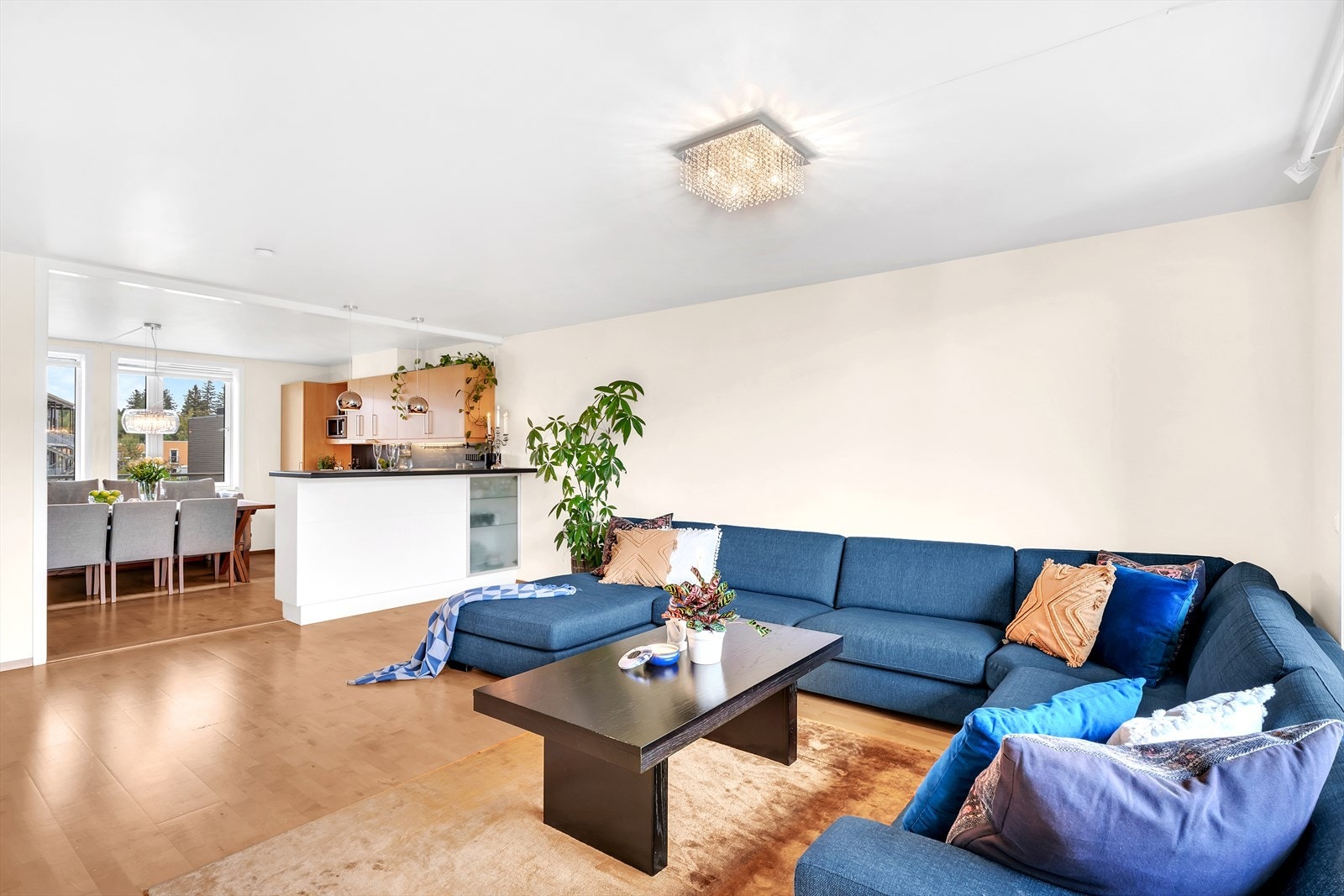 Det er åpen løsning mellom stue og kjøkken, som sørger for at man kan holde praten i gang under kokkeleringen Galleribilde