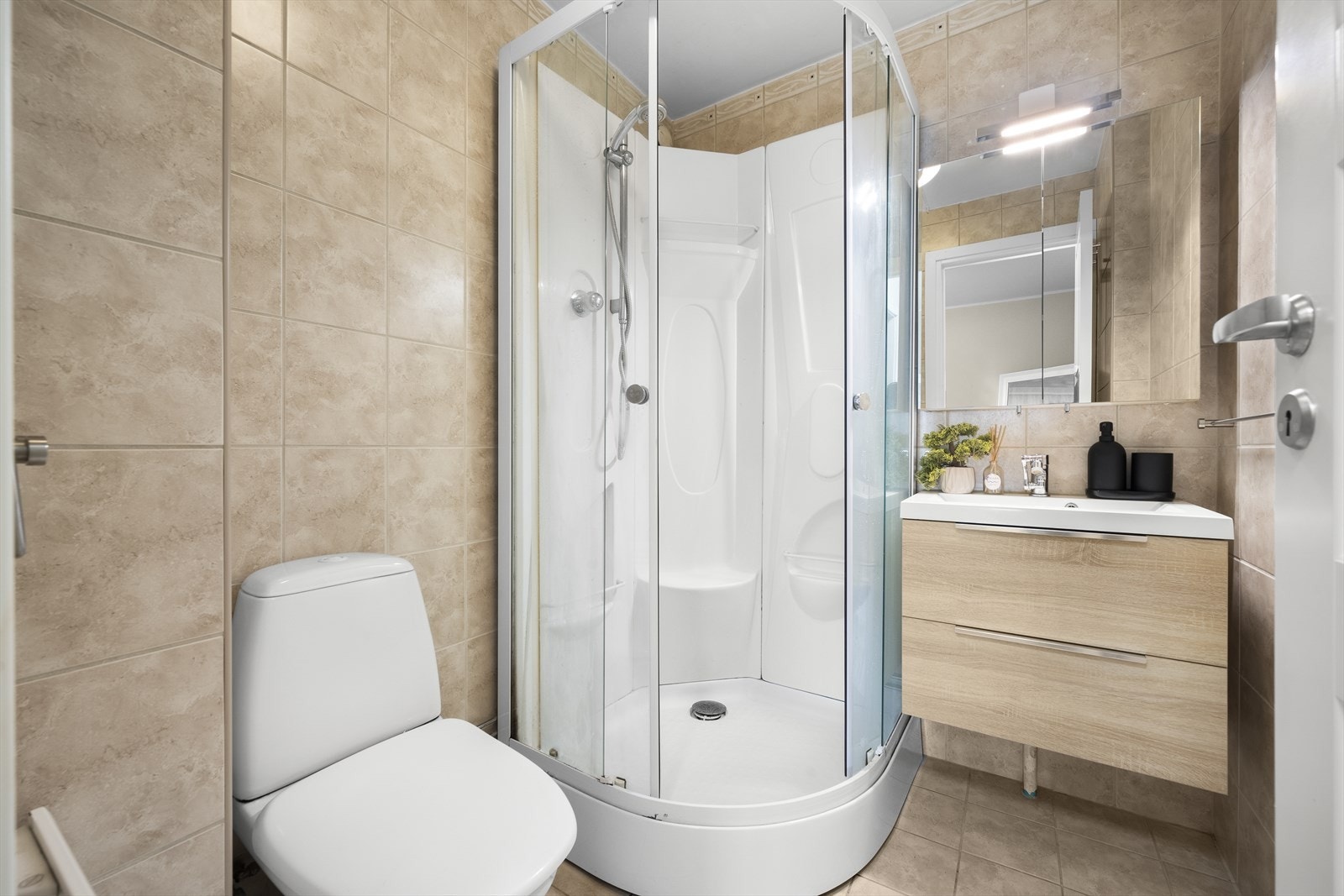 Flott flislagt bad med elektrisk panelovn. Galleribilde