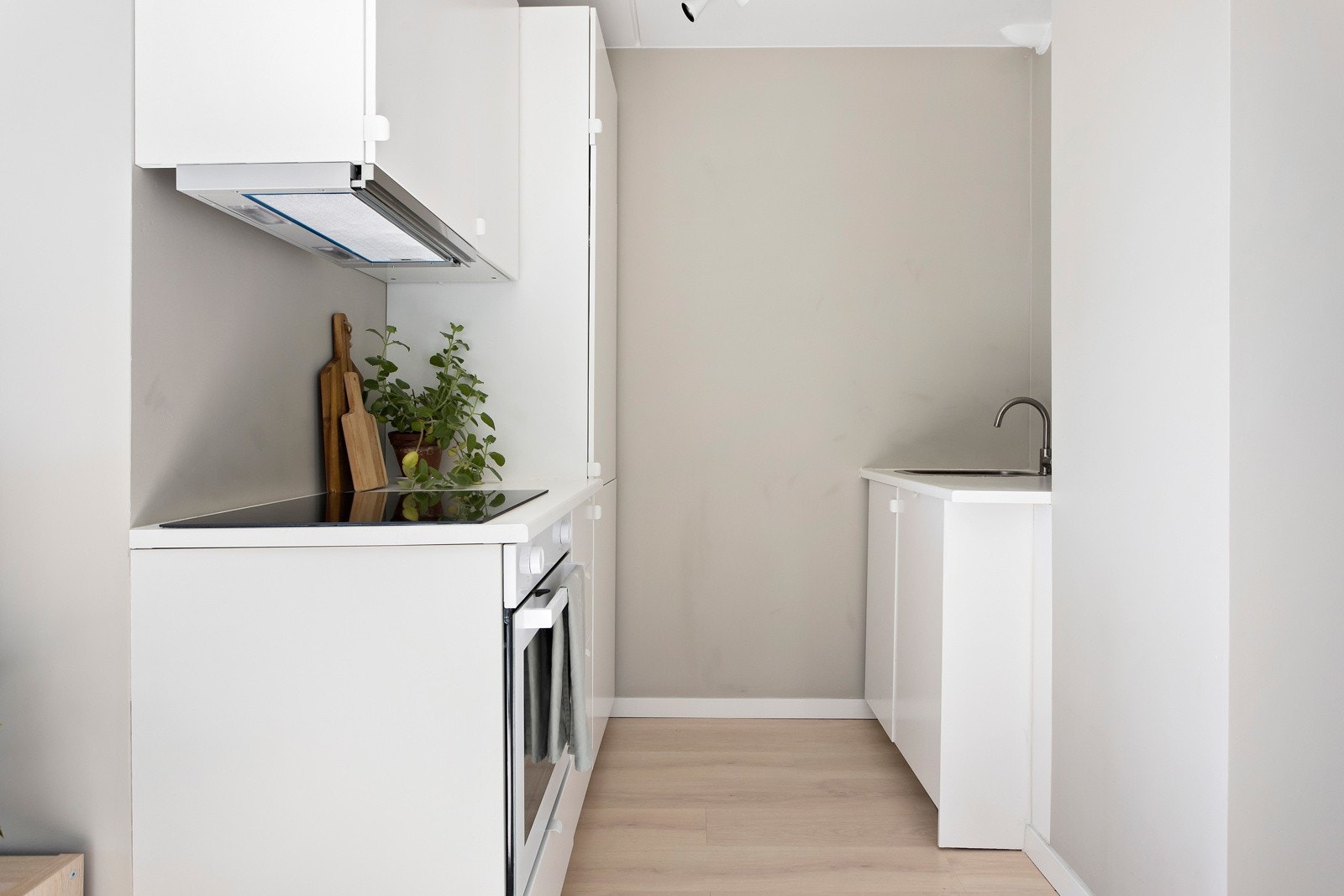 Lekkert kjøkken fra 2023 i tidsriktig utforming i plassbesbarende åpen løsning mot stuen Galleribilde