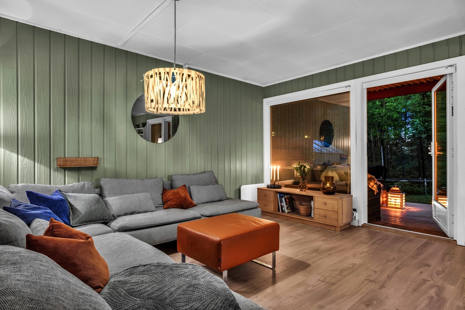 Stuen er romslig og åpen, med grønnmalte vegger og gulv belagt med laminat som skaper en innbydende atmosfære. Galleribilde