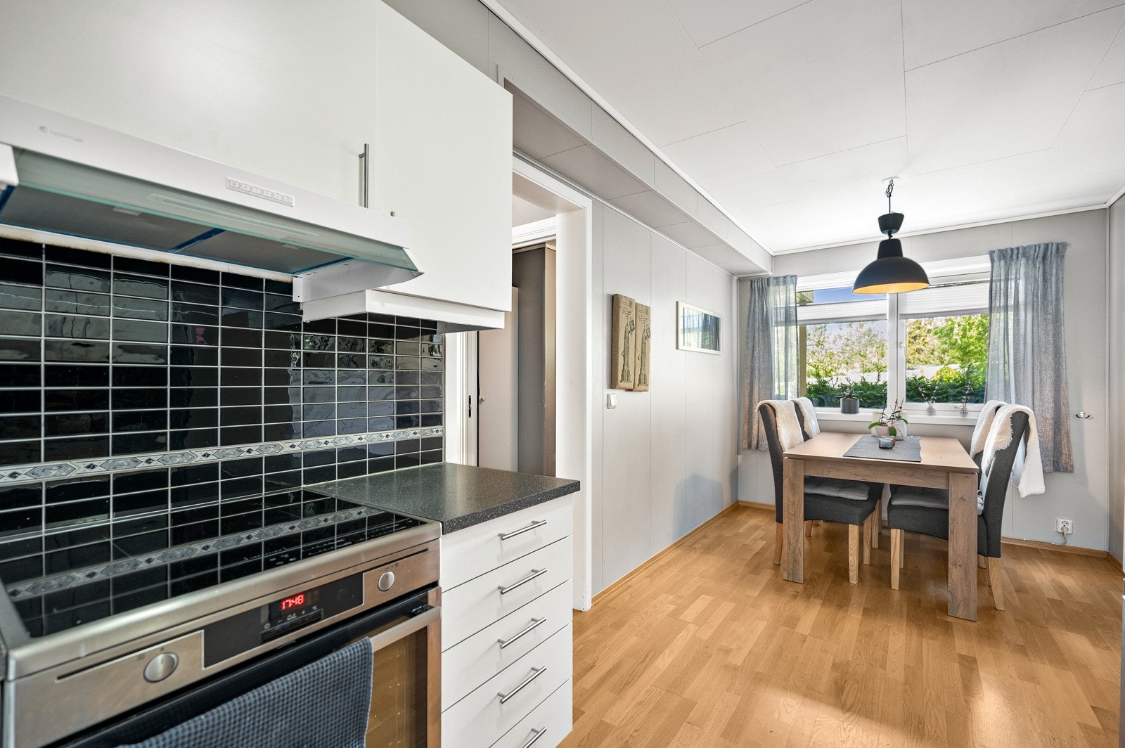 Trivelig kjøkkeninnredningen og består av lyse profilerte fronter og benkeplate i laminat med glatte flater mellom benkeplate og overskap. Galleribilde