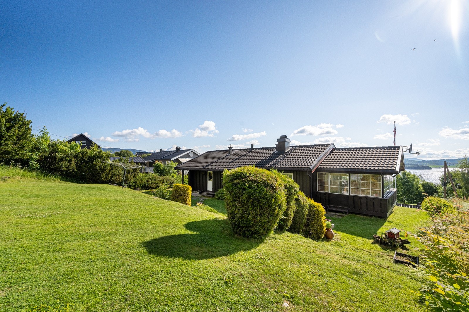 Romslig tomt pent opparbeidet med plen og diverse beplantning. Galleribilde