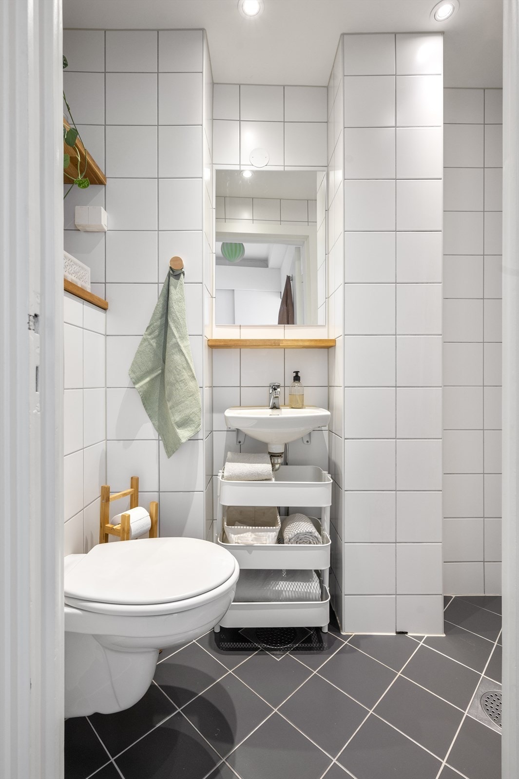 Lyst og delikat baderom med flislagte overflater, varme i gulv og downlights i himlingen Galleribilde