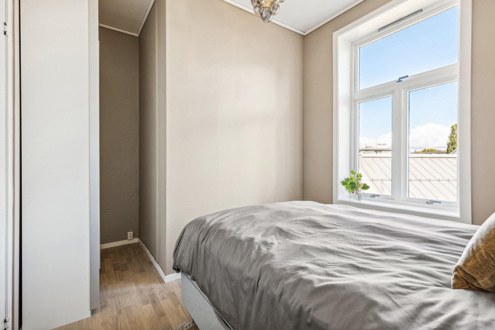 Soverommet er malt i fin lys farge og har pent gulv. Videre er det stort vindu som slipper inn naturlig lys! Galleribilde