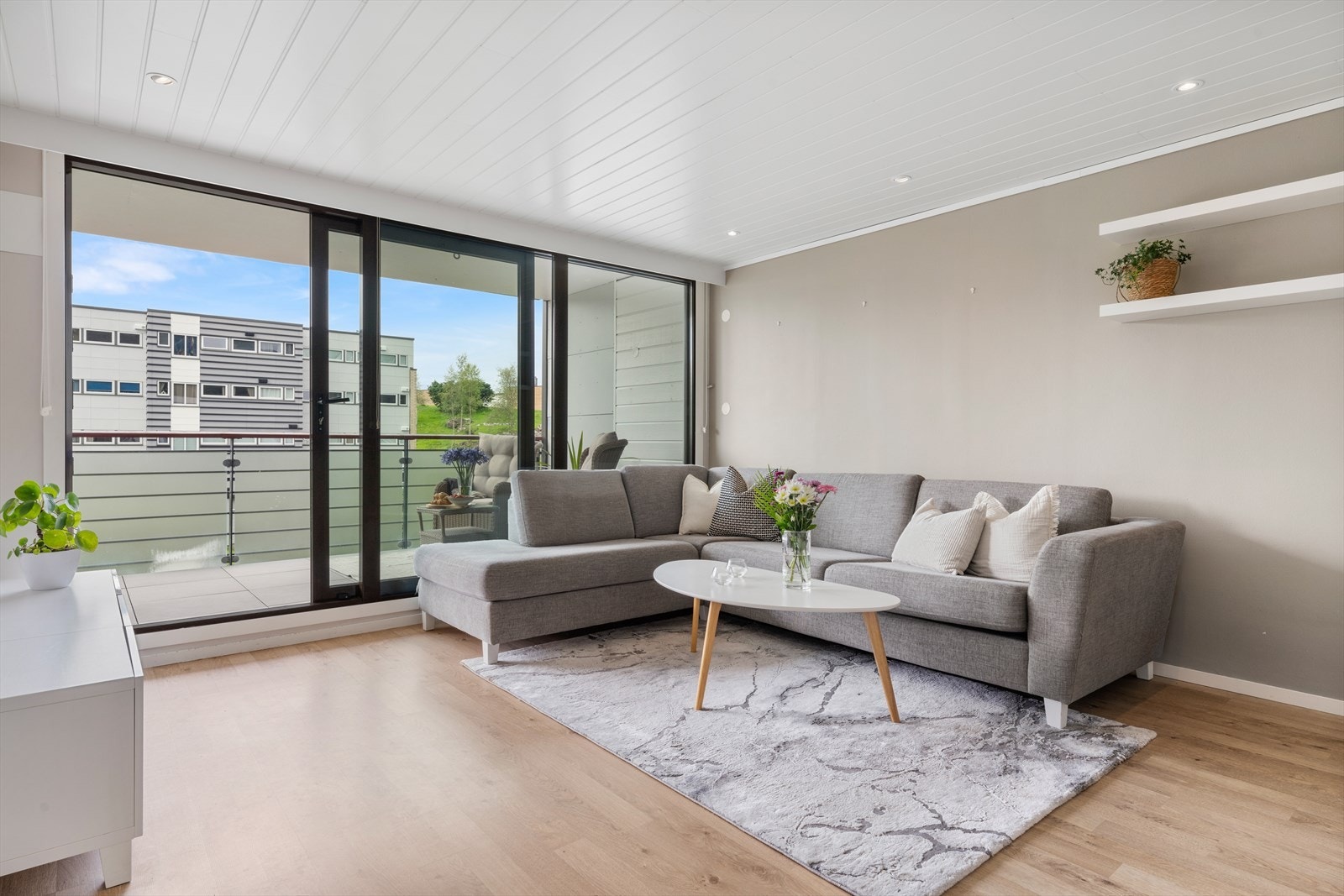 - Romslig stue med slette malte vegger og gulv i slitesterk laminat - Galleribilde