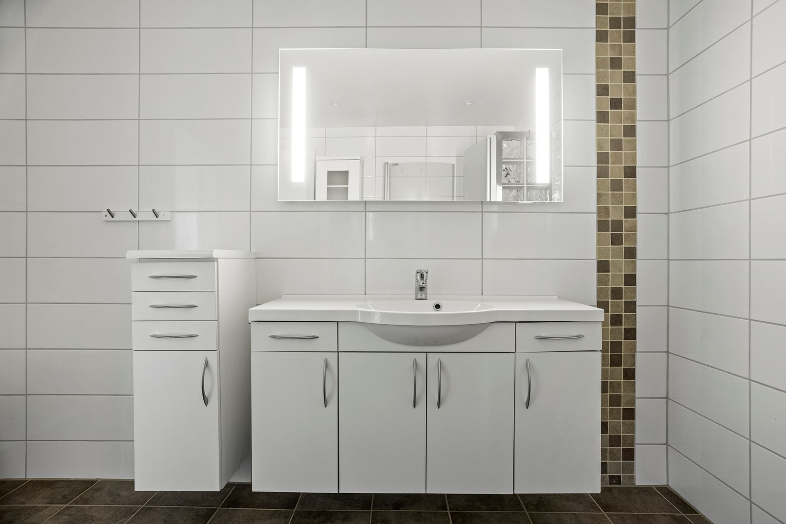 Badet er utstyrt med servantskap, innfellbare dusjdører og toalett Galleribilde