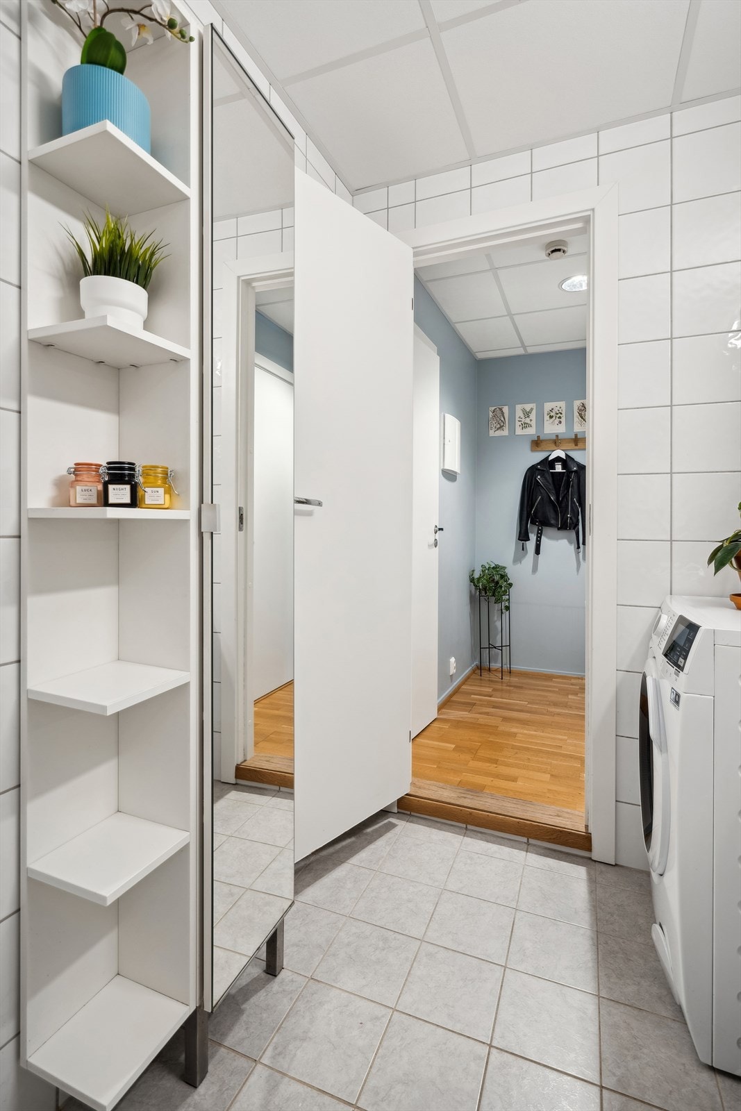 Badet er innredet med dusjhjørne, servantskap med god plass til oppbevaring av baderomsartikler, speil med overbelysning, veggskap og gulvmontert klosett. Det er opplegg for vaskemaskin. Galleribilde