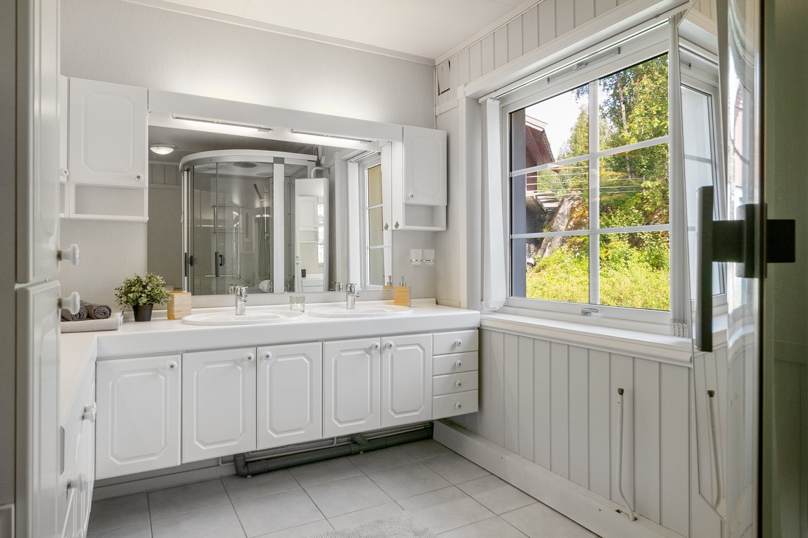 Bad i 1.etasje med dobbel servant på innredning, dusjkabinett og toalett. Galleribilde