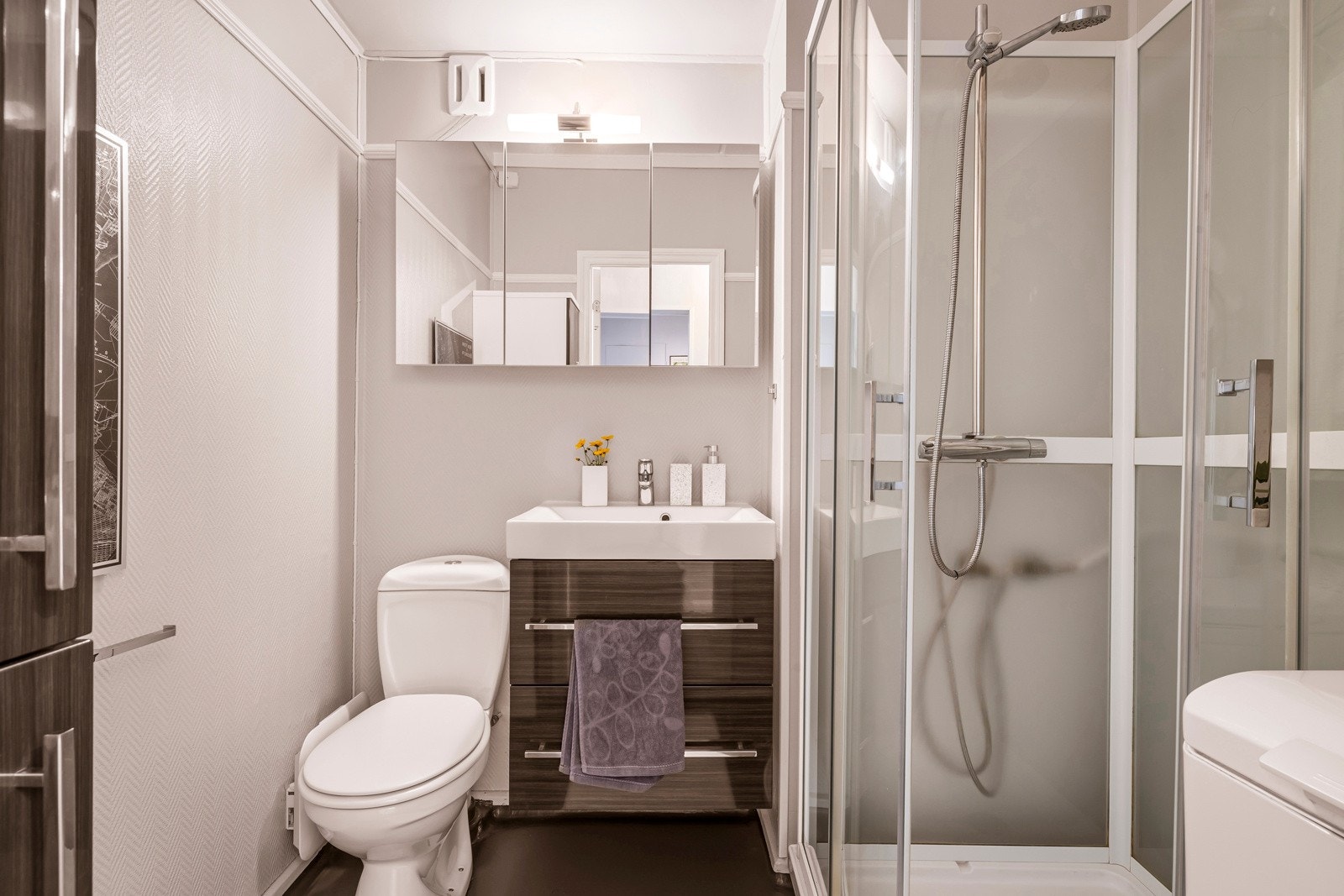 Badet er av fin størrelse, og innholder benkeskap med servant, dusjkabinett, gulvmontert toalett og opplegg for vaskemaskin. Galleribilde