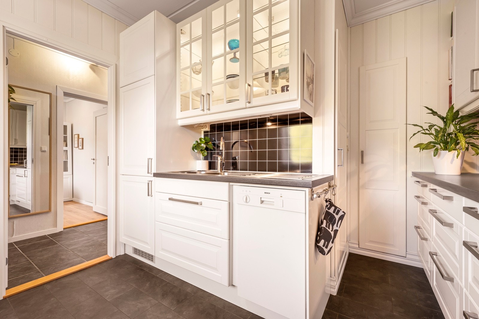 De integrerte hvitevarene, herunder stekeovn, induksjonsplatetopp og kombinert kjøl- og fryseskap, samt frittstående oppvaskmaskin, medfølger i handelen. Galleribilde