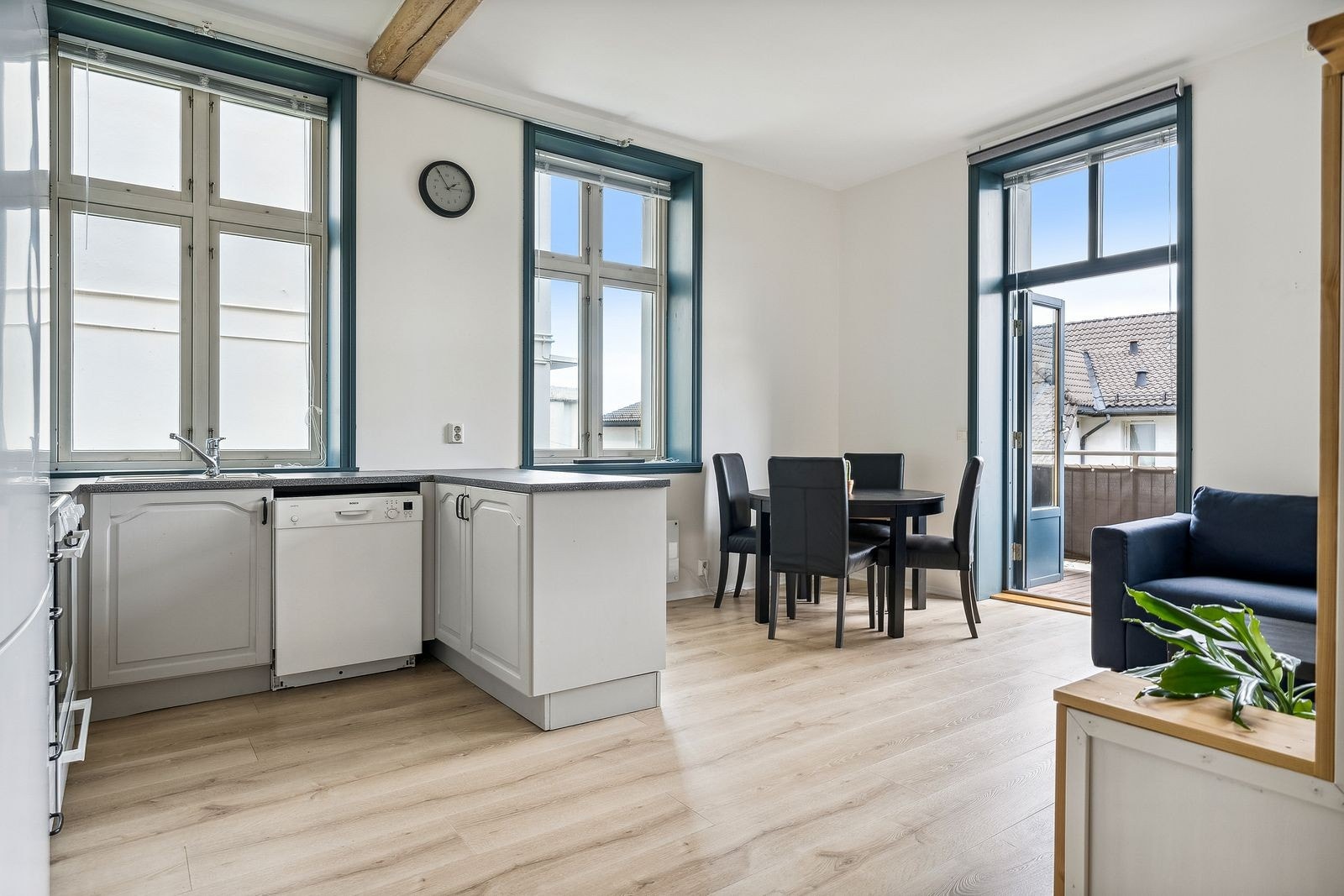 Spisebord med 4 stoler mellom kjøkken og utgang til balkong. Galleribilde