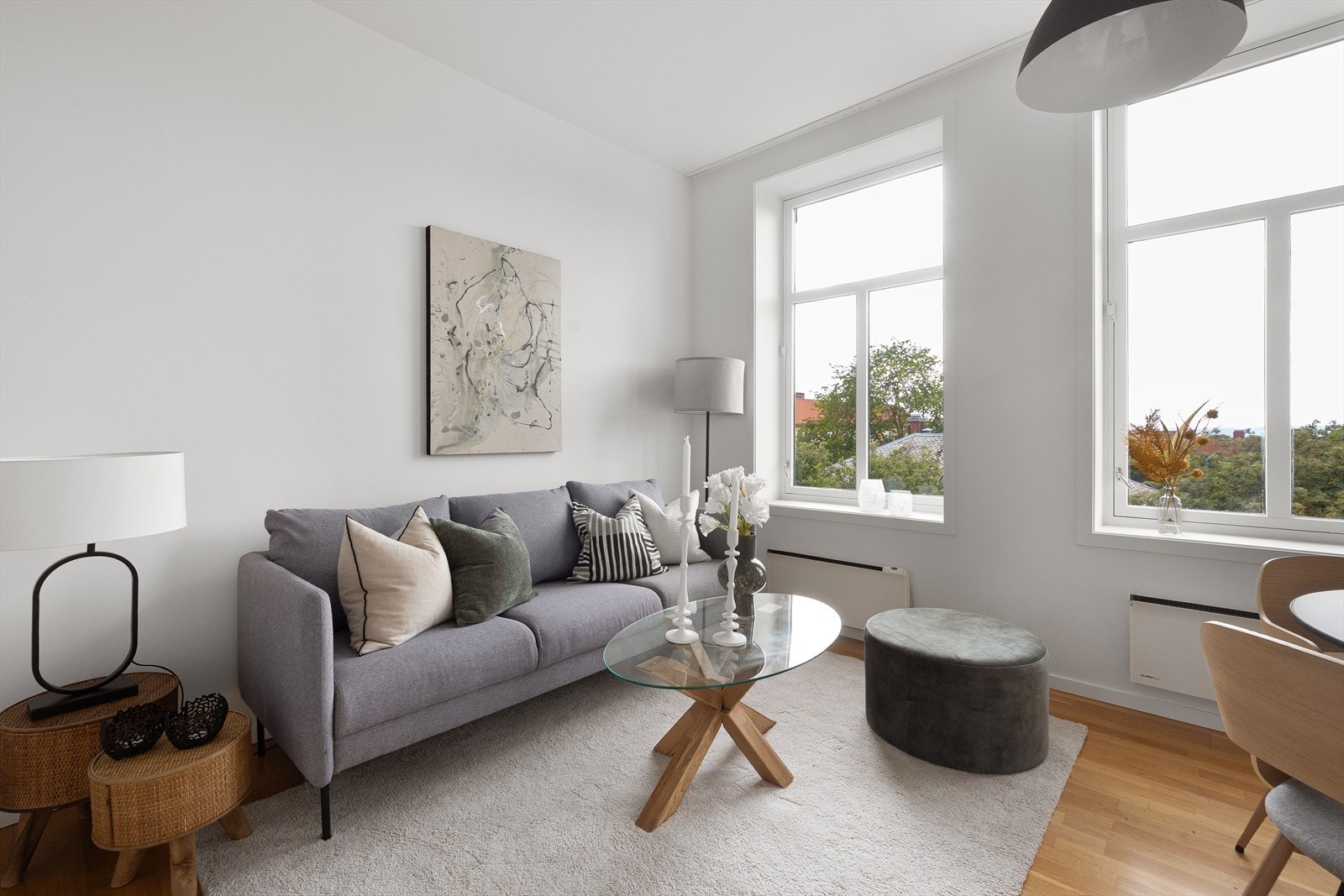 Leiligheten har en koselig stue med store vindusflater Galleribilde