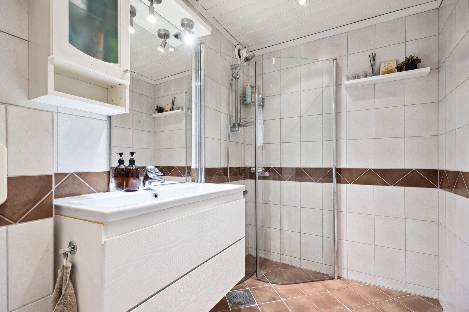 Flott flislagt bad med gulvvarme fra 2007. Vegghengt servant innredning, og sammenleggbare dusjdører. Galleribilde