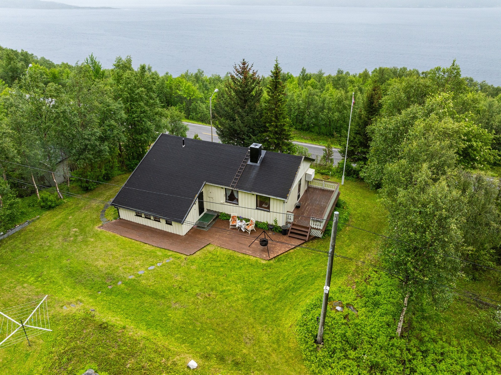 Eldre enebolig på en flate med råkjeller, garasje og utebod Galleribilde