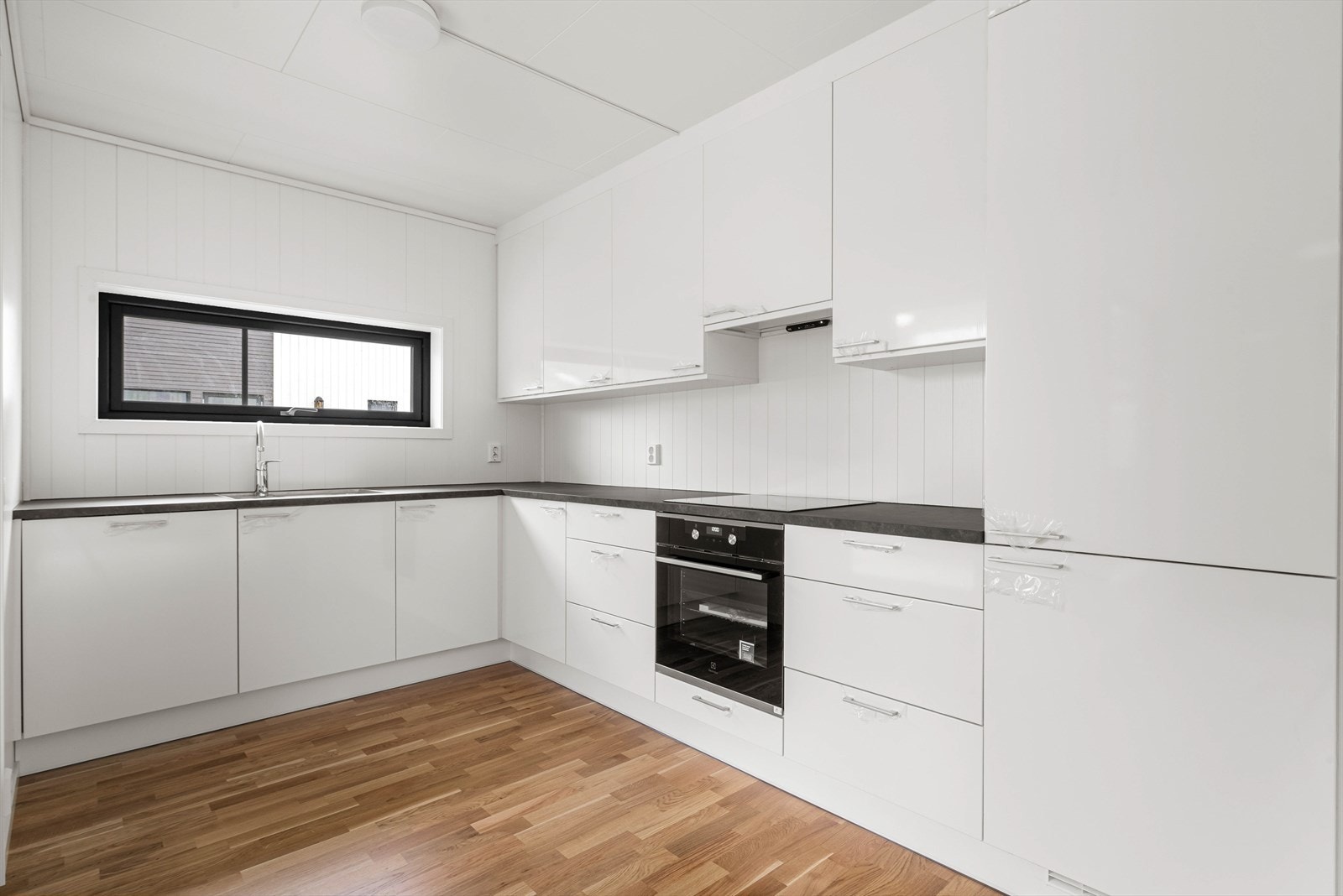 Det flotte kjøkkenet byr på integrerte hvitevarer og induksjonstopp, og det er godt med skap- og benkeplass. Galleribilde