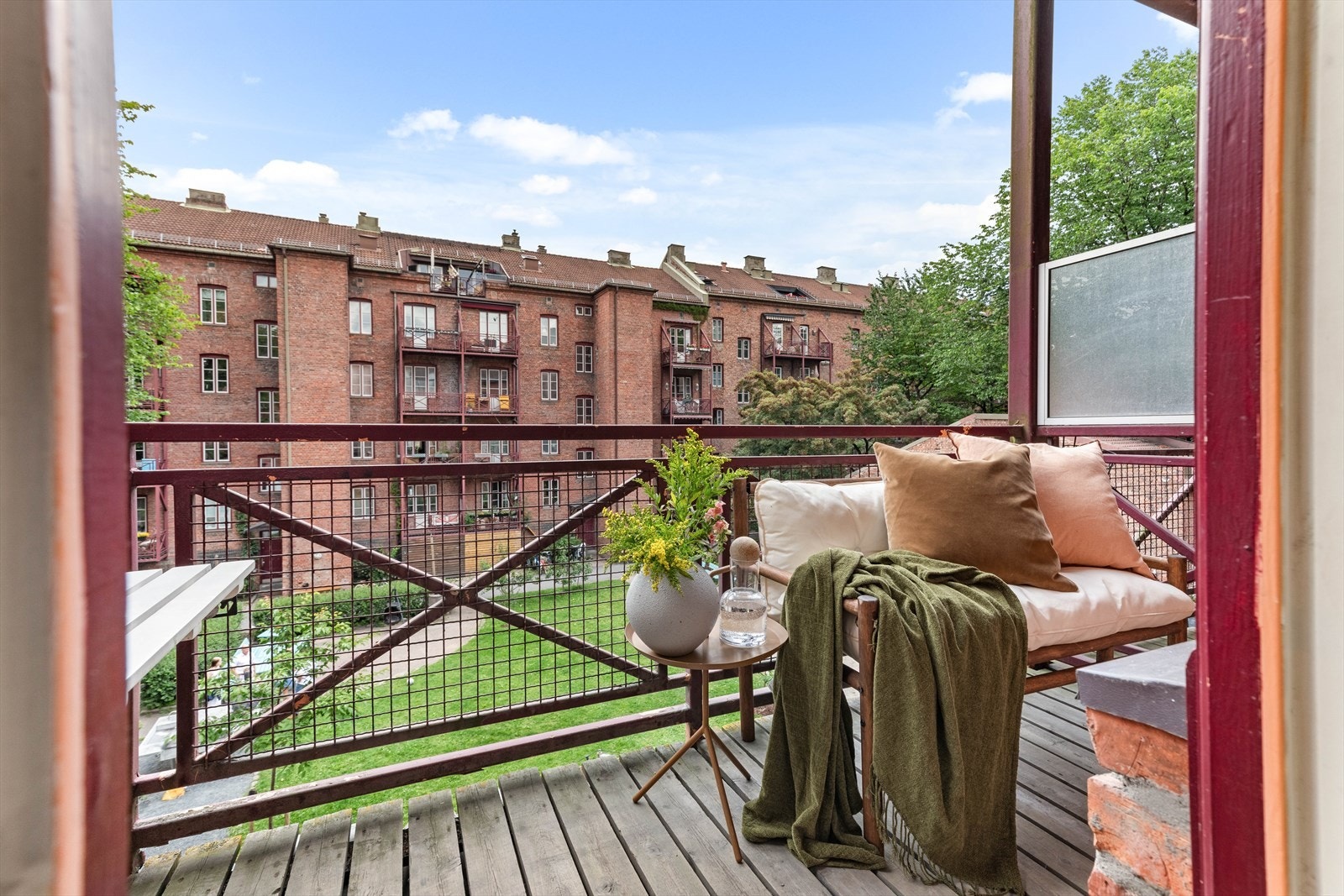 Rolig bakggård med utsikt mot magnoliatrær, lekeplasser og drivhuset. Galleribilde