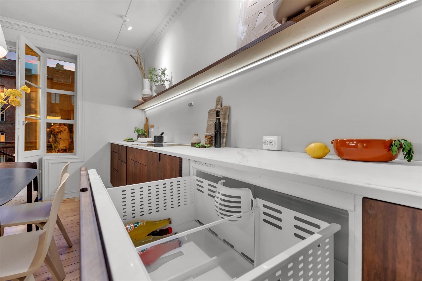 I tillegg til integrert kombiskap har man to kjøleskuffer og en ekstra fryser under kjøkkenbenken. Galleribilde