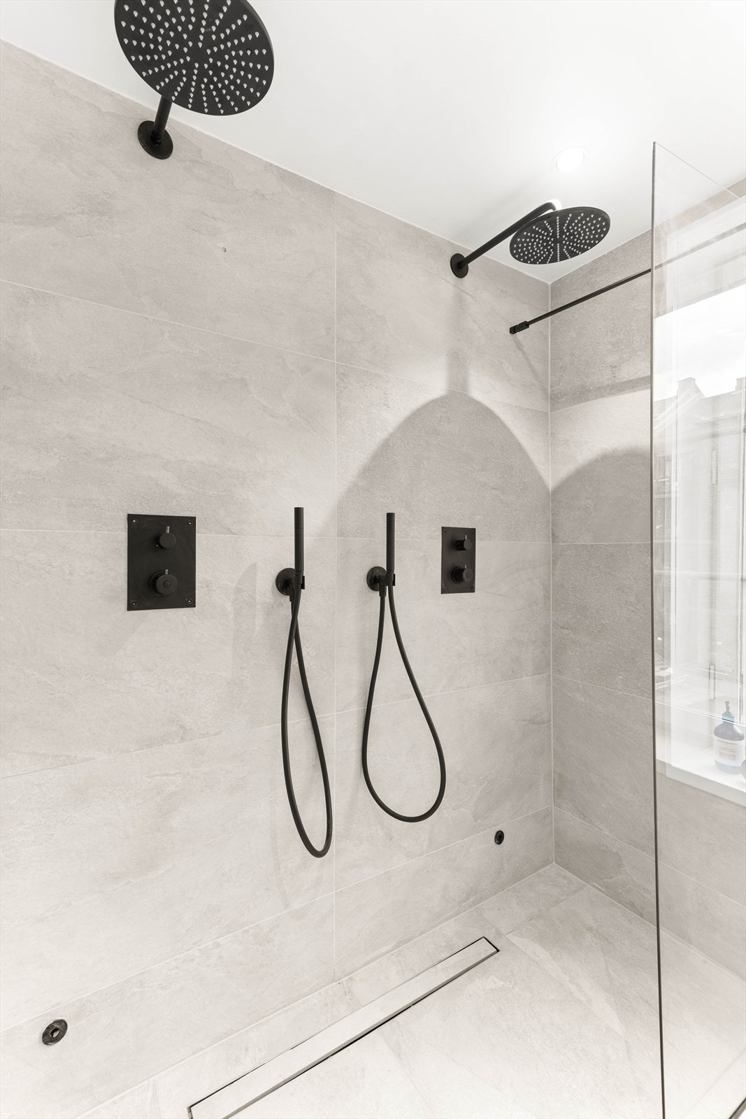 Det er etablert dobbel trykk- og termostatstyrt innbyggingssystem med ha nddusj og taksil i sort utførelse fra "Tapwell". Sluket er skjult med flis i samme stil. Galleribilde