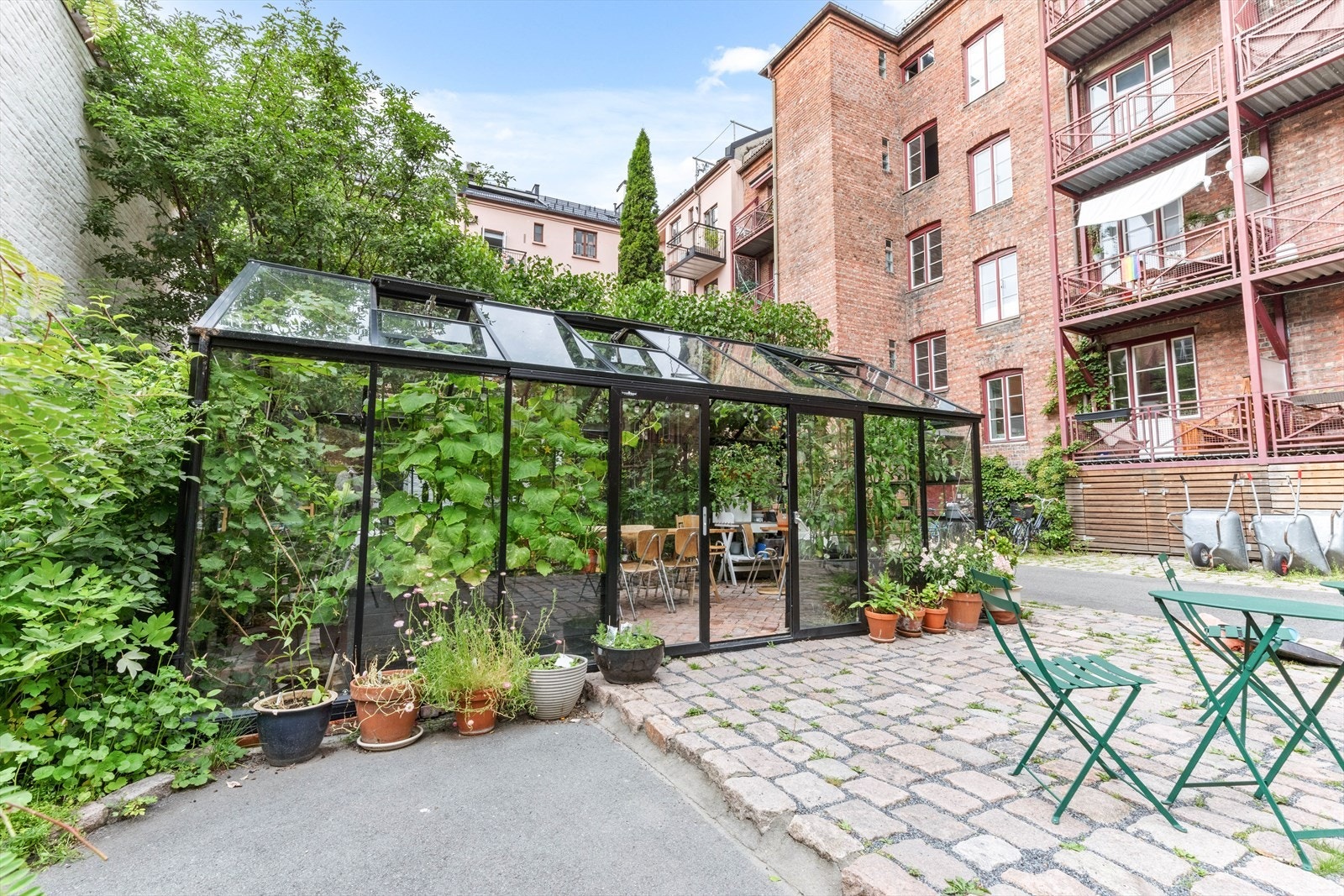 I bakgården er det magnoliatrær, lekeplasser og et romslig drivhus, som beboerne også bruker til et glass og en matbit. En liten grønnsakhage gir nok avling til at beboerne hver høst serveres tretti liter kortreist suppe med blant annet potet, rødbet, løk Galleribilde