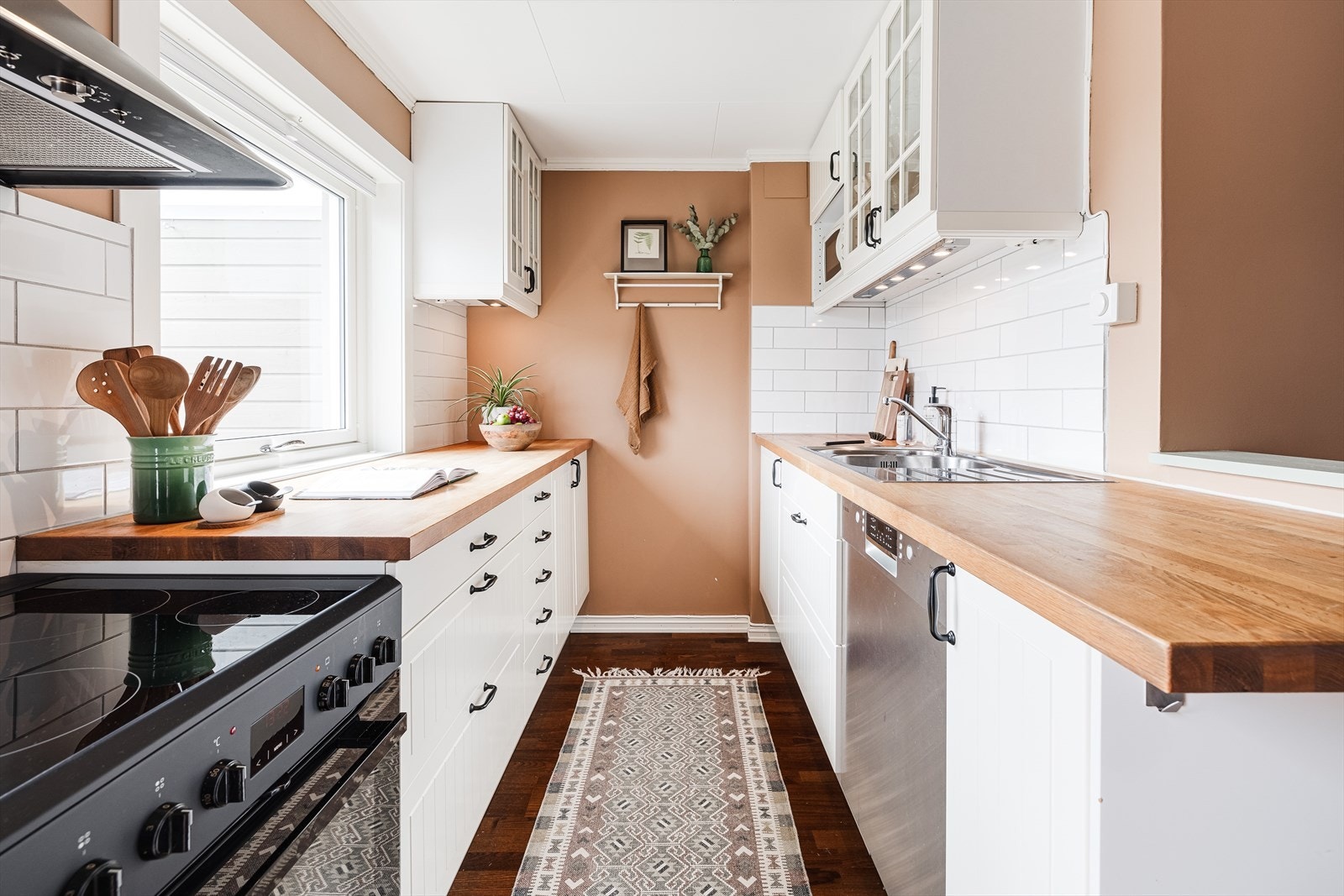 Flott IKEA kjøkken fra 2012 med hvite profilerte fronter og overskap med glass. Heltre benkeplate med en tykkelse på 38 mm med overlimt dobbel oppvaskkum med svingbart blandebatteri fra Damixa Galleribilde