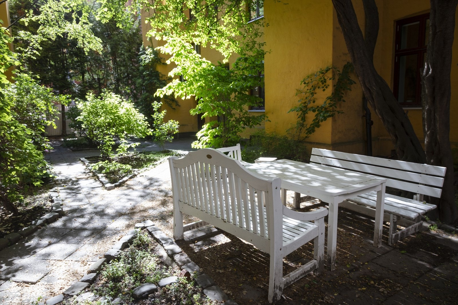 Bakgården er pent opparbeidet med flotte sittegrupper, beplantninger og trær. Galleribilde