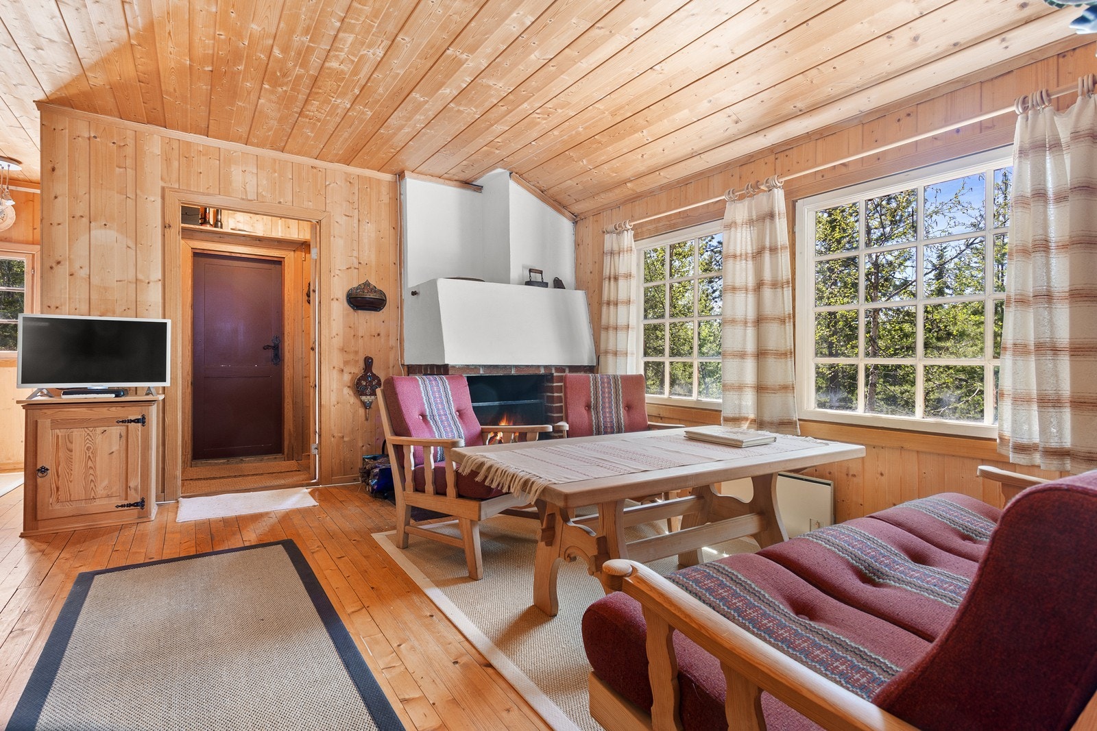 Lys og koselig stue med gulv og panel på vegg av furu. Galleribilde