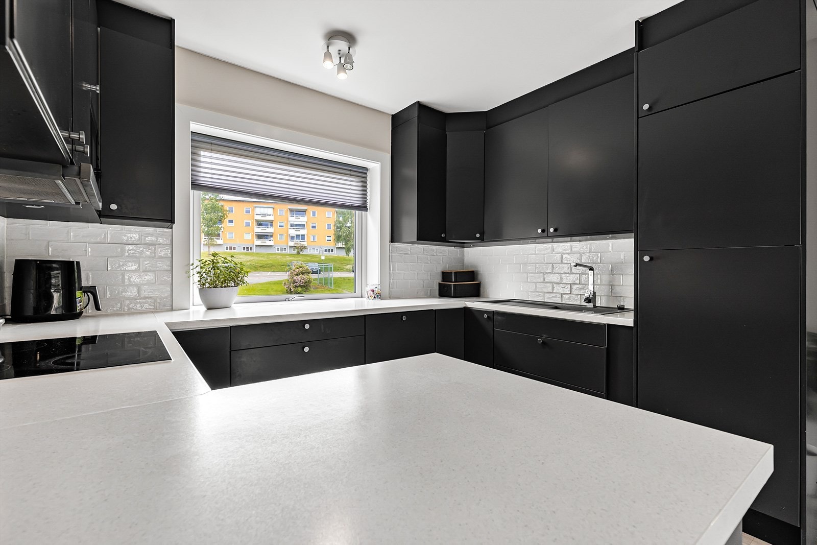 Det er montert fliser mellom overskap og benkeplate for beskyttelse av vegg samt lys under overskap for ekstra benkebelysning. Galleribilde