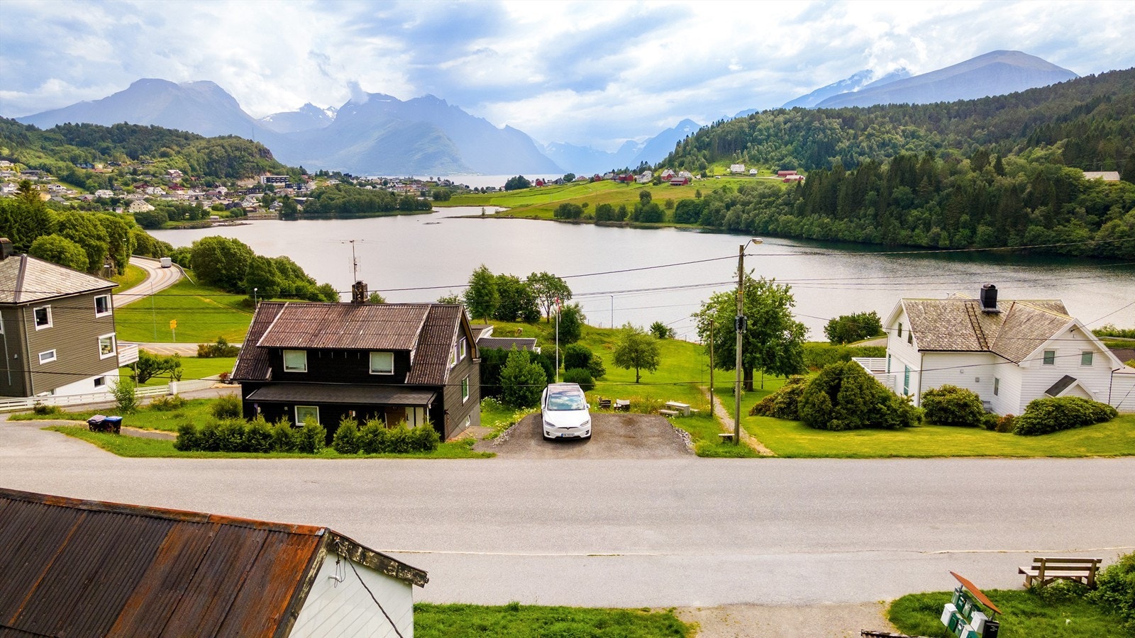 Nydelig utsikt mot Solavågen og over fjorden mot Hundeidvika, med Sunnmørsalpane praktfult i bakgrunnen Galleribilde