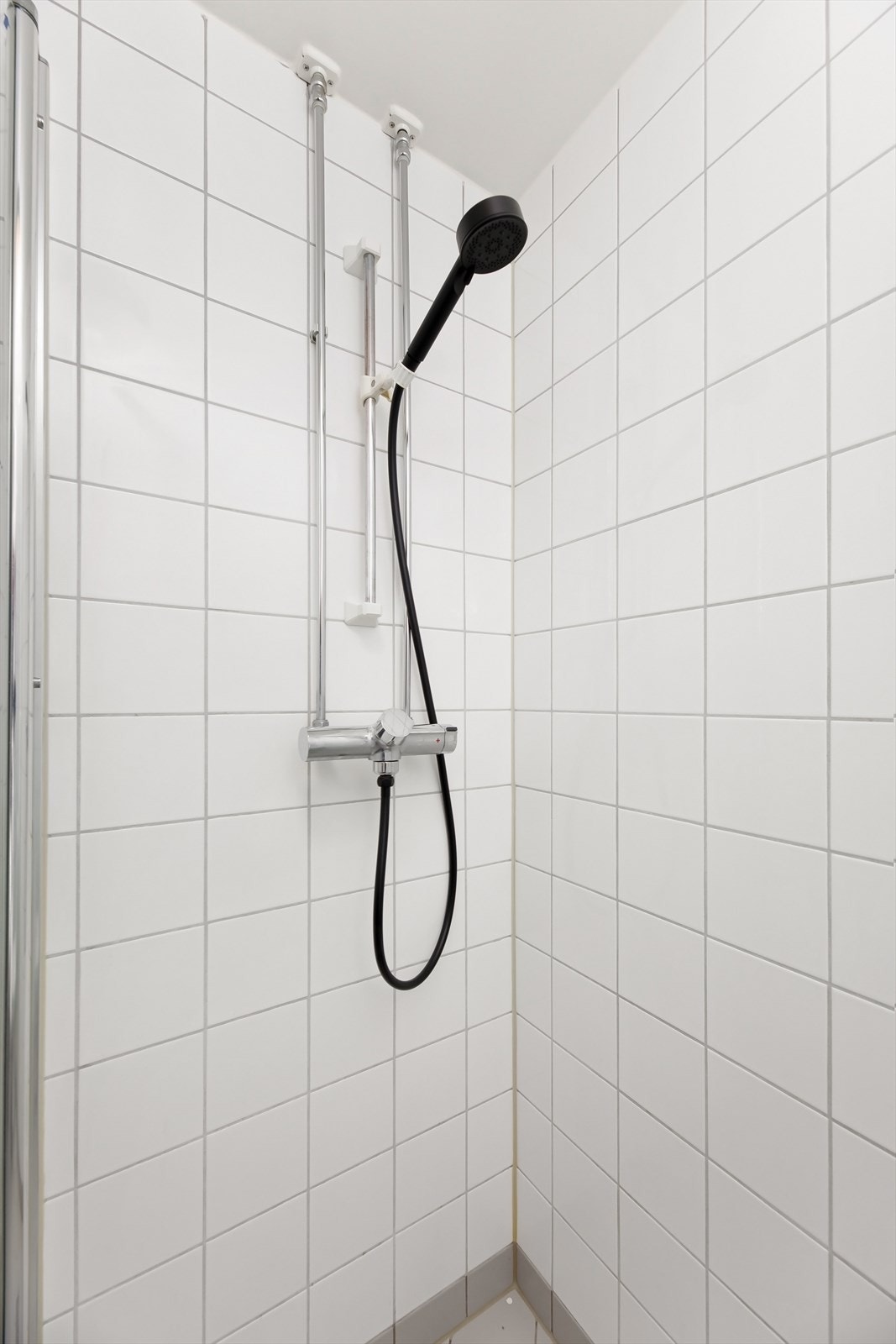 Badet er innredet med klosett, servant nedfelt i innredning, speilskap med belysning og dusjhjørne med svingbare glassdører. Galleribilde