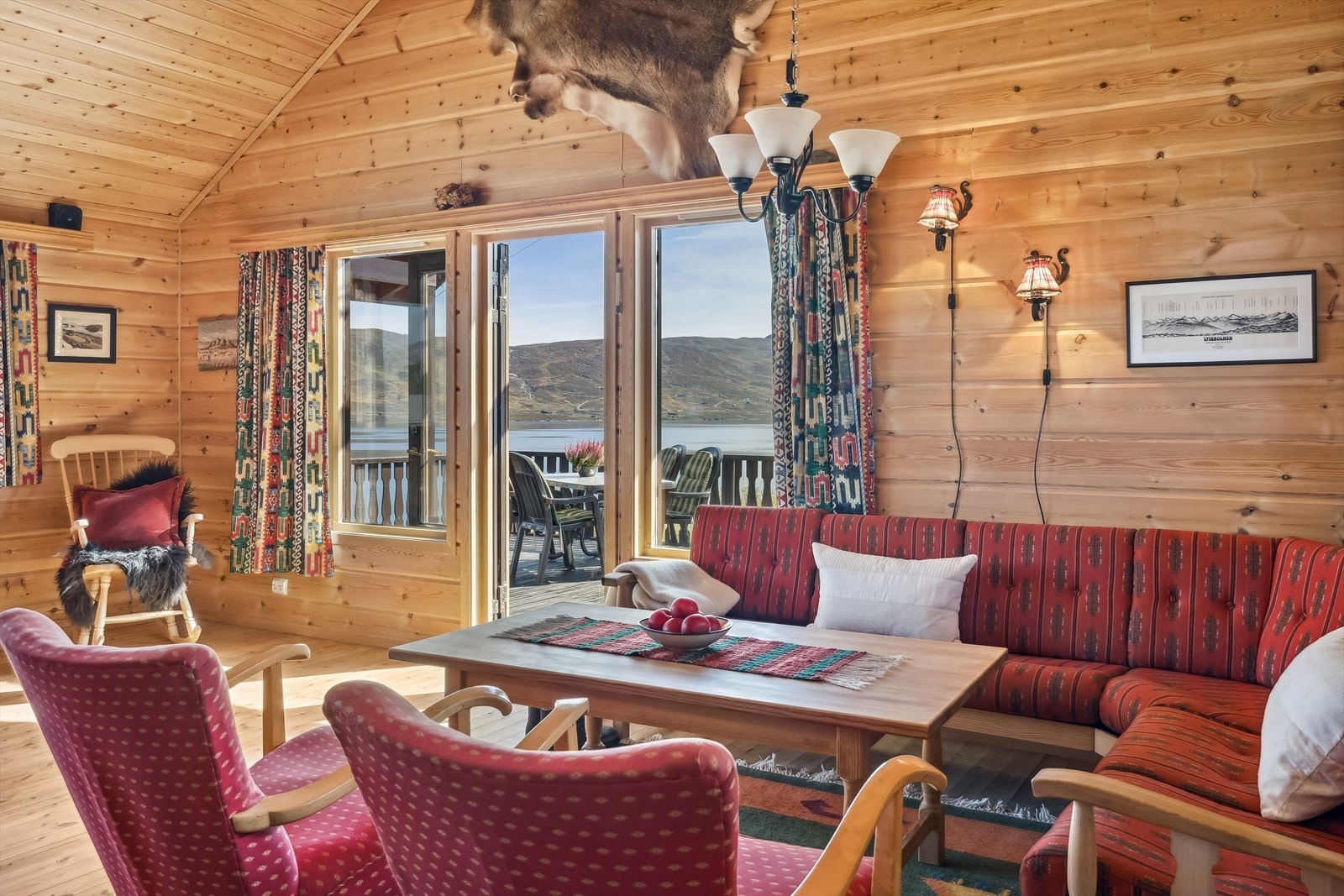 Stue med tradisjonelle panelte overflater, trepanel i tak og gulv av furu. Galleribilde