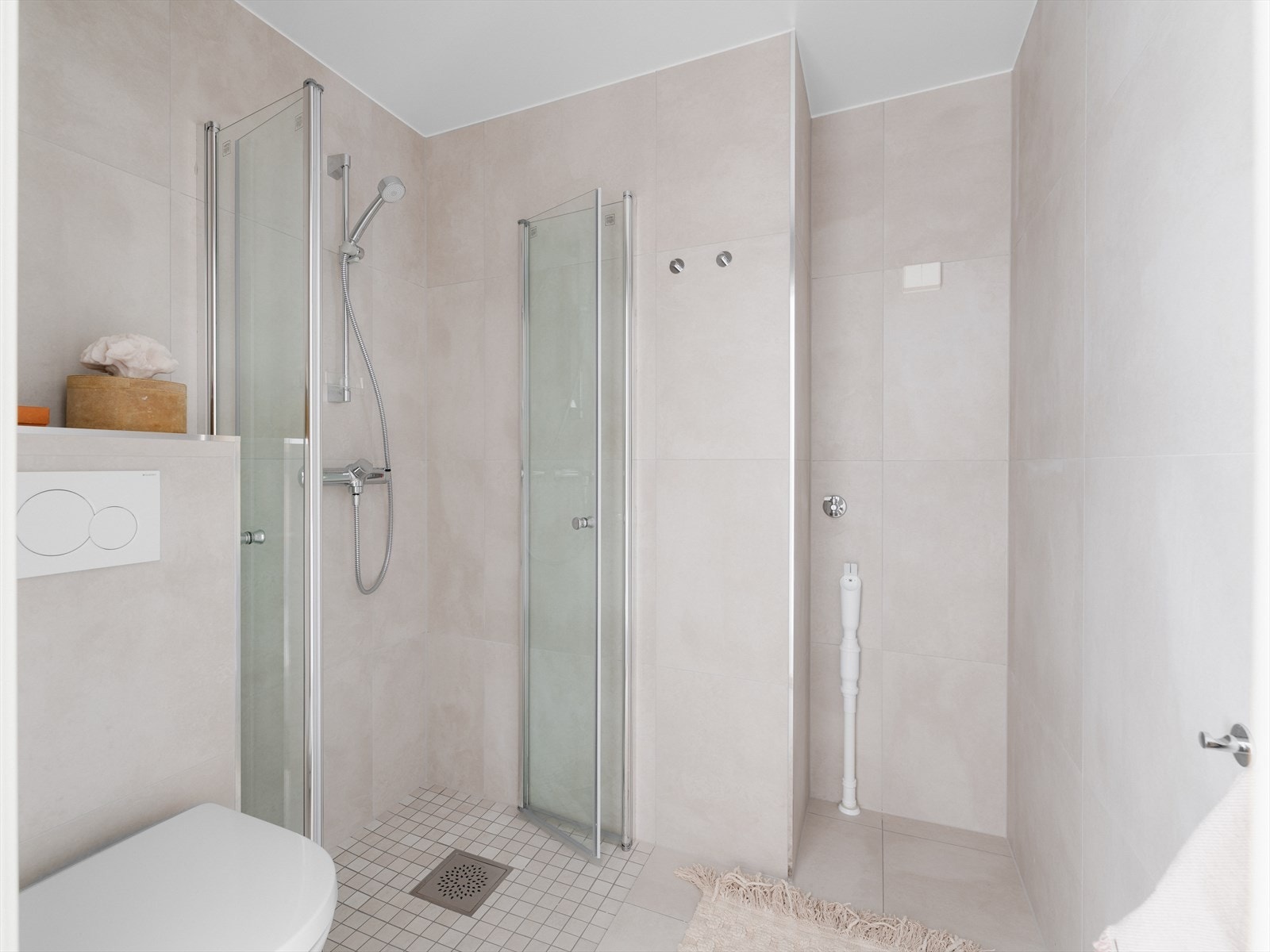 Det arealsmarte badet ble oppgradert i 2024, og har tidløse lyse fliser på gulv og vegger. Her har du også varmekabler i gulv, som holder føttene varme. Galleribilde