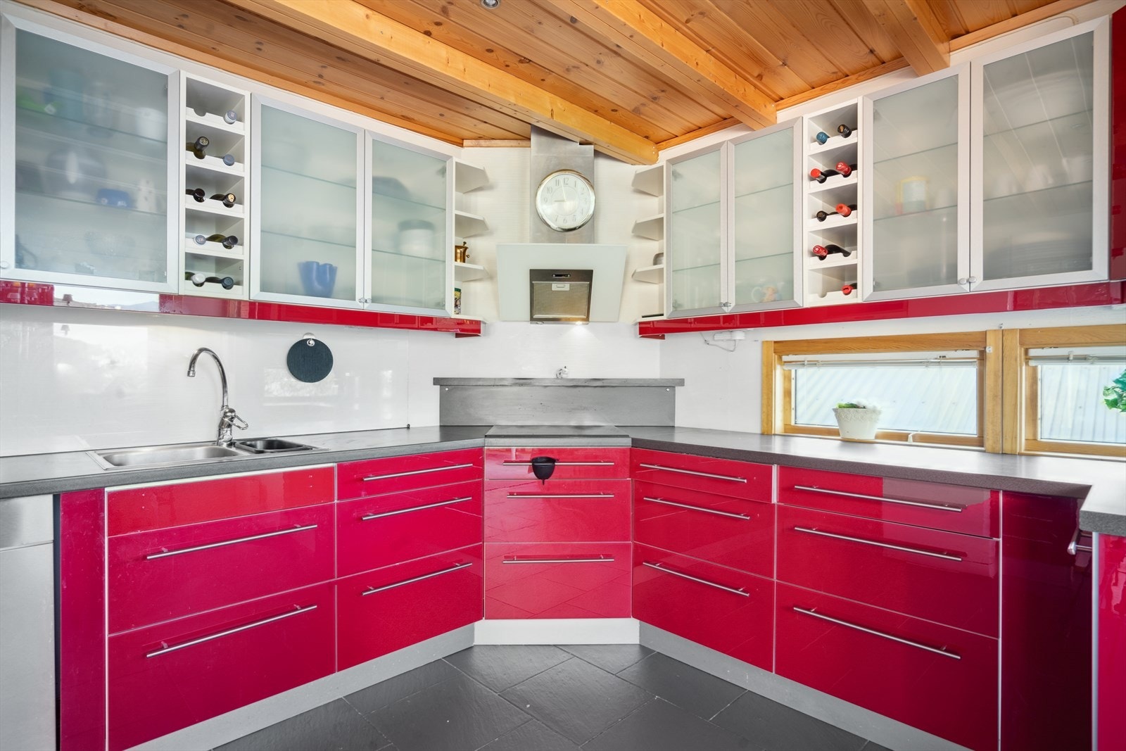 Kjøkkeninnredning har en dyp rødførge med cromdetaljer Galleribilde