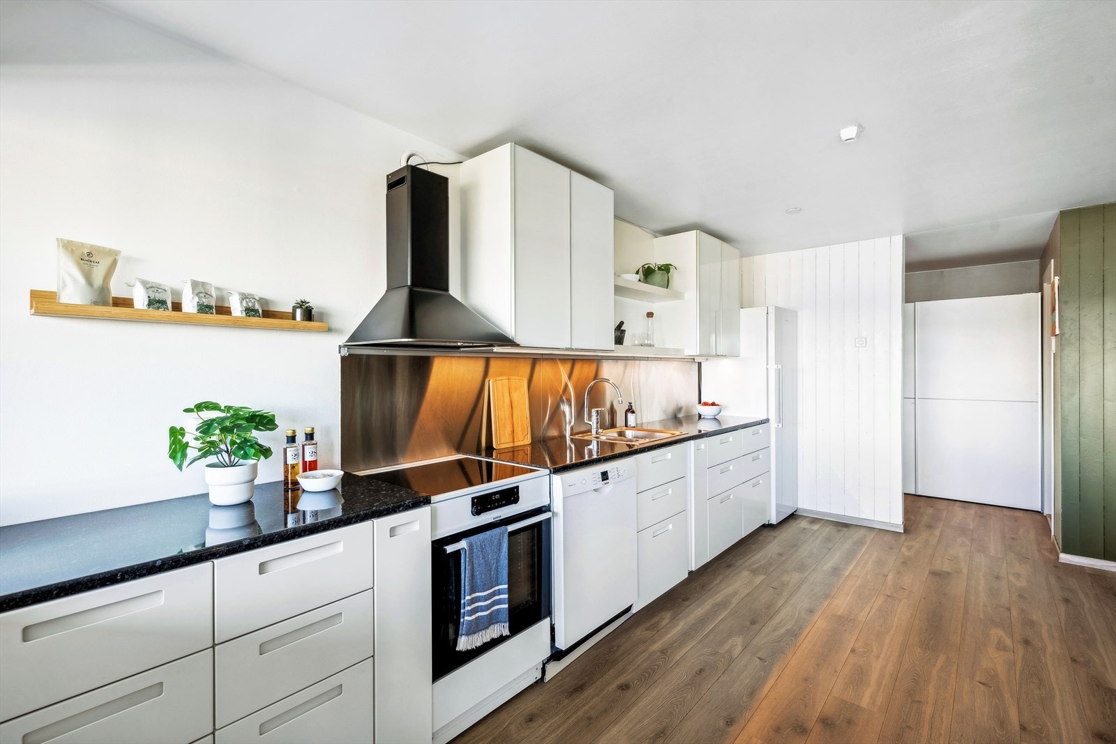 Kjøkkenet har lyse, slette fronter og en mørk benkeplate. Her er det rikelig med både skap- og benkeplass. Galleribilde