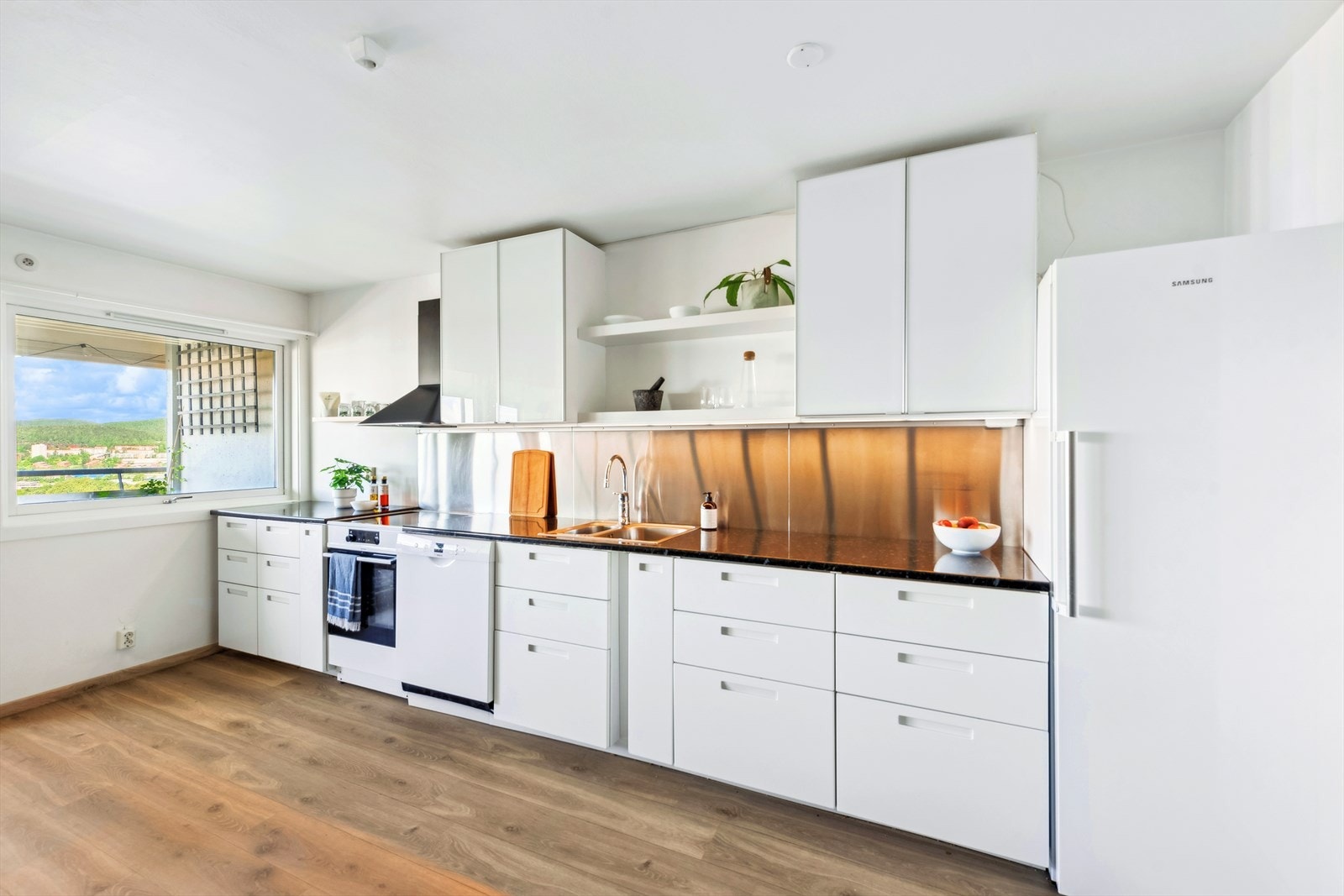 Den åpne løsningen mellom stuen og kjøkkenet gir rommet et luftig preg. Galleribilde