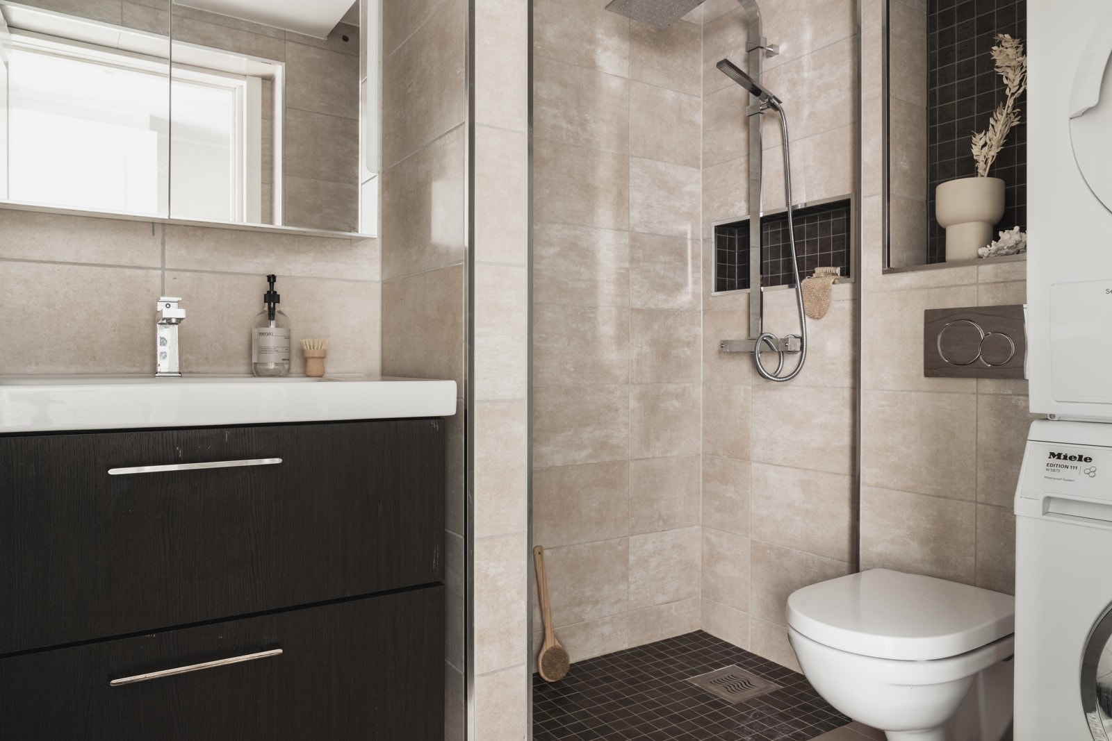 Helfliset og moderne bad på 4 kvm med en arealeffektiv løsning, varmekabler i gulv og opplegg til vaskemaskin samt tørketrommel. Galleribilde