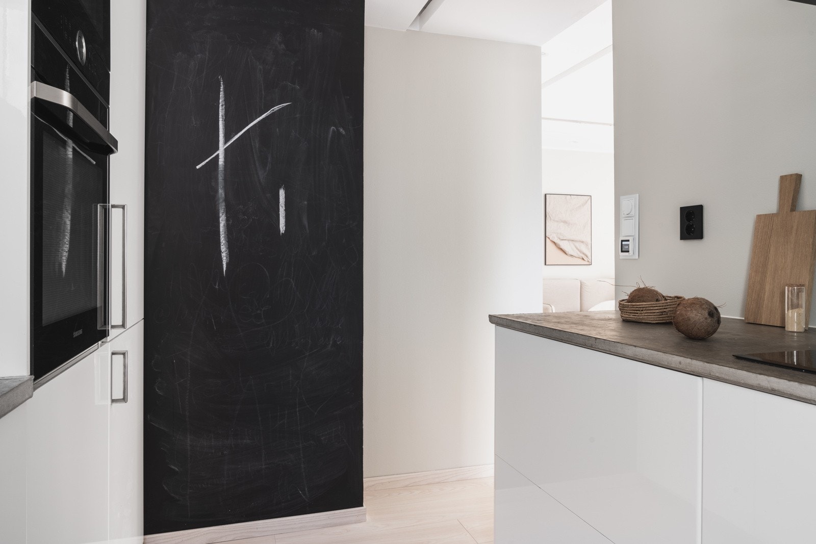 Det er plassbygd med benkeplate av betong og skapdører med slette hvite fronter i høyglans. Galleribilde