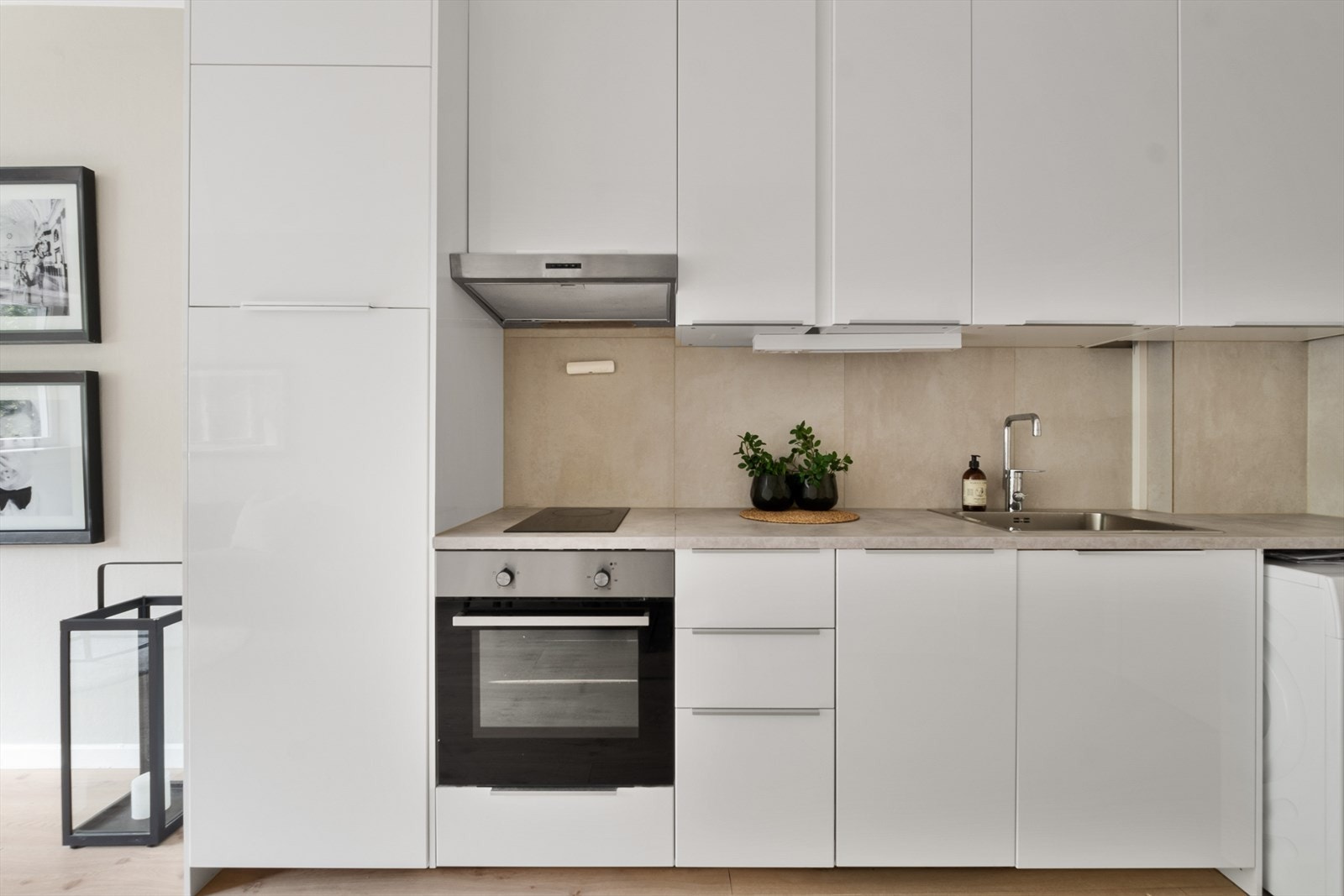 IKEA kjøkken fra 2015 med moderne, hvite fronter, laminat benkeplate, keramisk topp, integrert komfyr, oppvaskmaskin (smal) og kjøleskap med fryser. Avsatt plass til vaskemaskin. Galleribilde