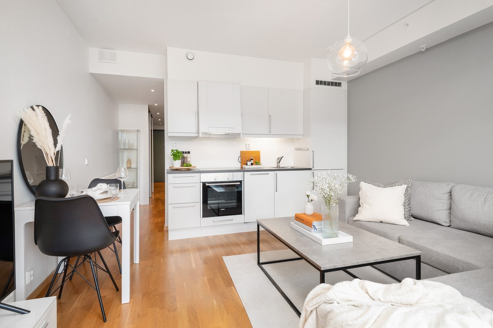 Hjemmets samlingspunkt inkluderer stue og kjøkken i en åpen løsning på 14 m². Her har man god plass til sofaseksjon, spisebordsløsning og TV-hjørne. Vindusflatene strekker seg fra topp til bunn og bidrar til en lys og luftig romfølelse. Galleribilde