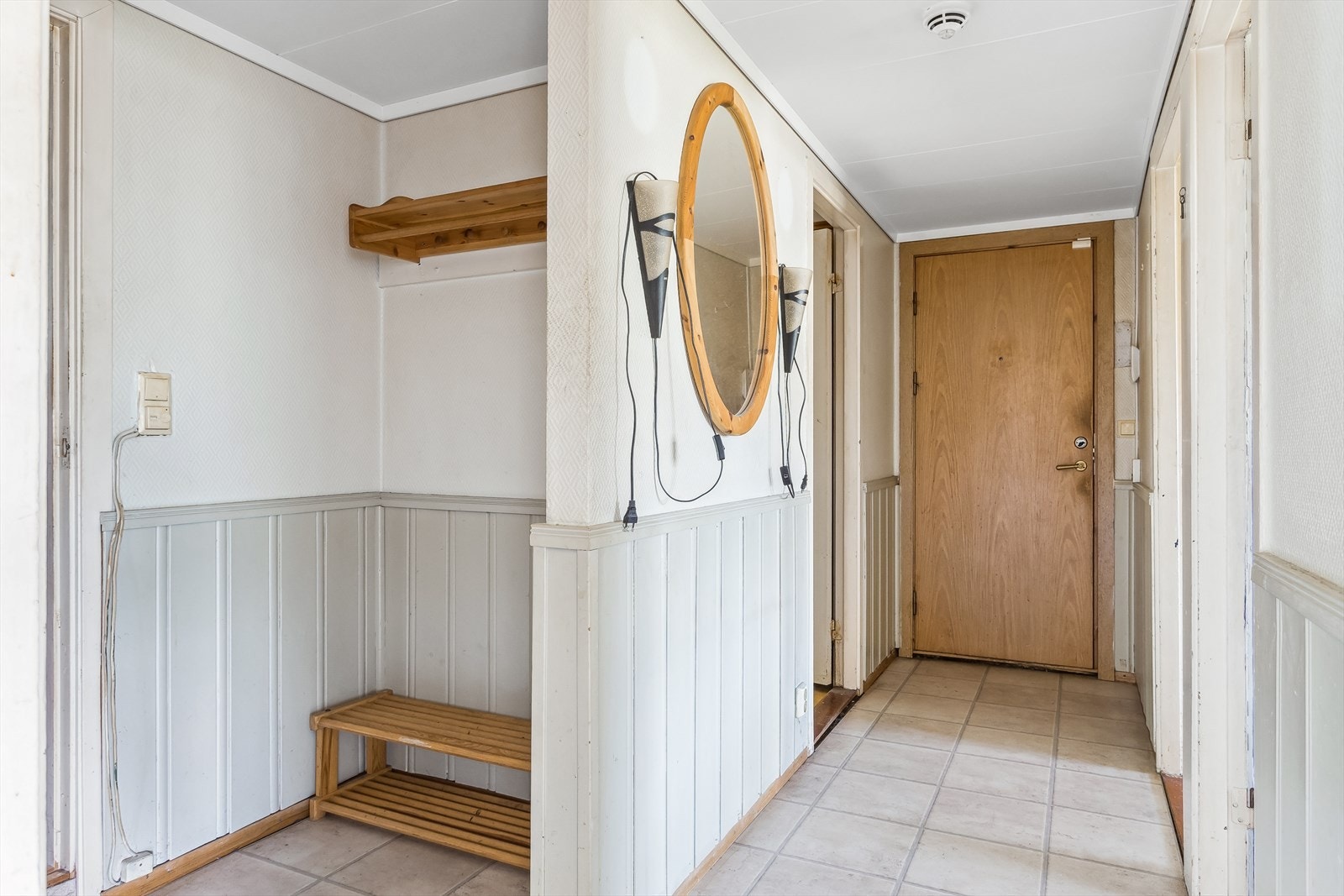 Romslig entrè med plass til oppbevaring av både jakker og sko. Det er fliser på gulv og det er montert døråpner i entréen. Galleribilde