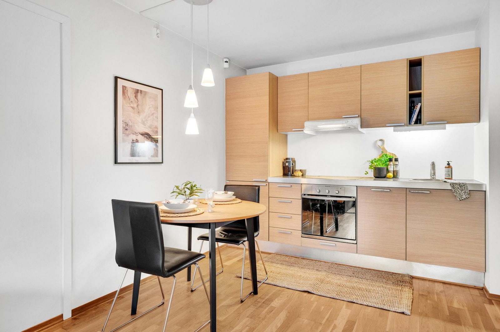 Spisebord i tilknytning til kjøkkenet. Det er etablert takpunkt for belysning som bidrar til en hyggelig atmosfære rundt middagsbordet. Galleribilde