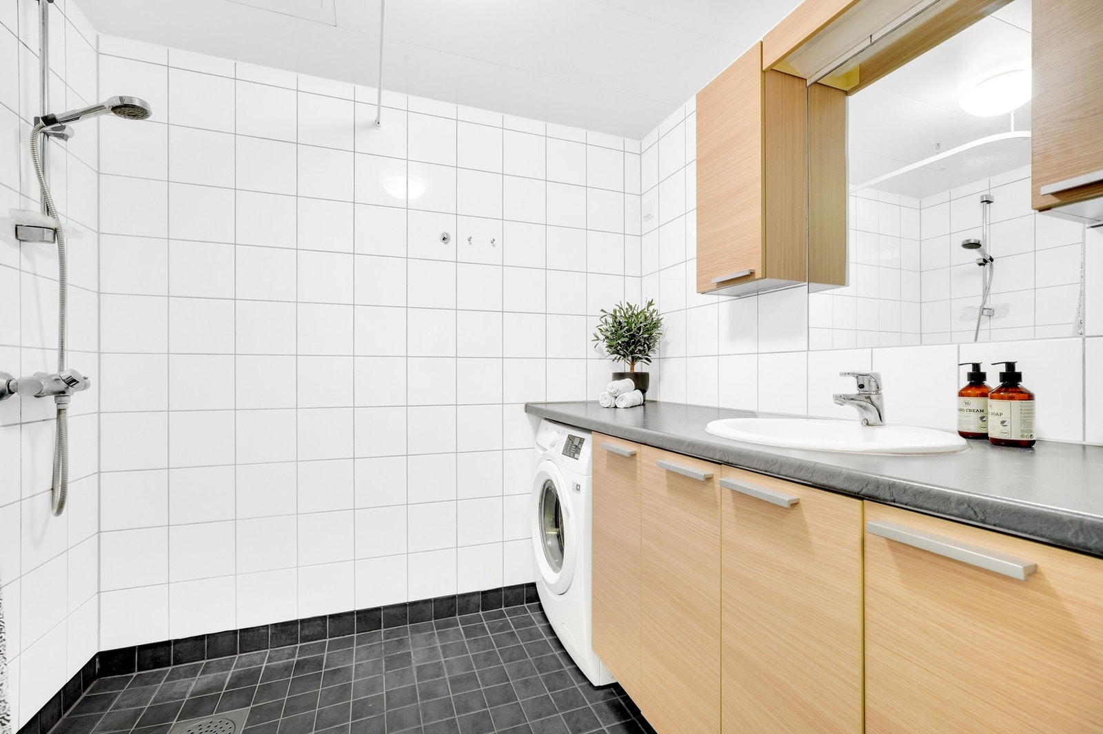 Med en stor baderomsplate som strekker seg fra vegg til vegg har du ekstra godt med lagringsplass for baderomsartikler. Kran og avløp for vaskemaskin. Galleribilde