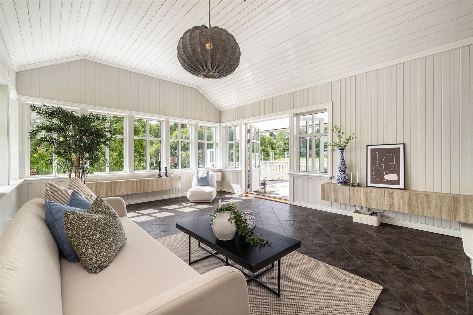 Den flotte stuen har fliser på gulvet, og det er utgang til den solrike, vestvendte terrassen med markise og god plass til utemøbler. Galleribilde