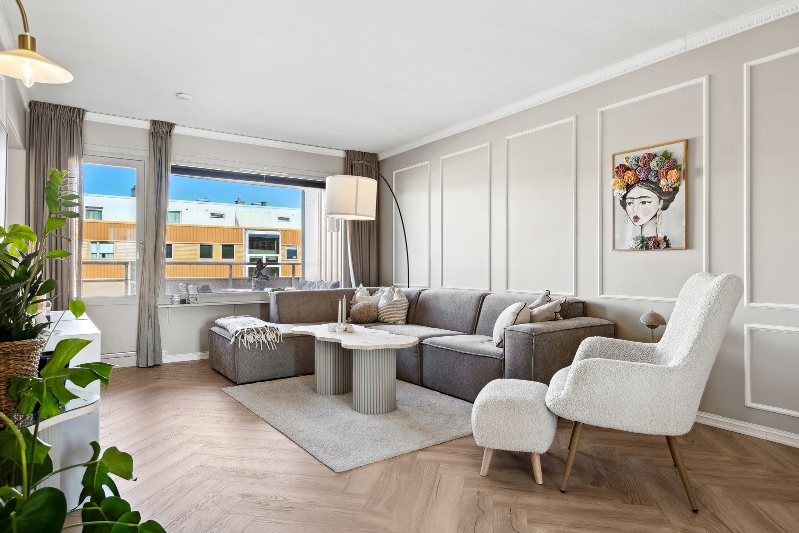 Her er det valgt et moderne uttrykk med fiskebenslaminat, plassbygd bokhylle og pyntelister på vegg. Galleribilde