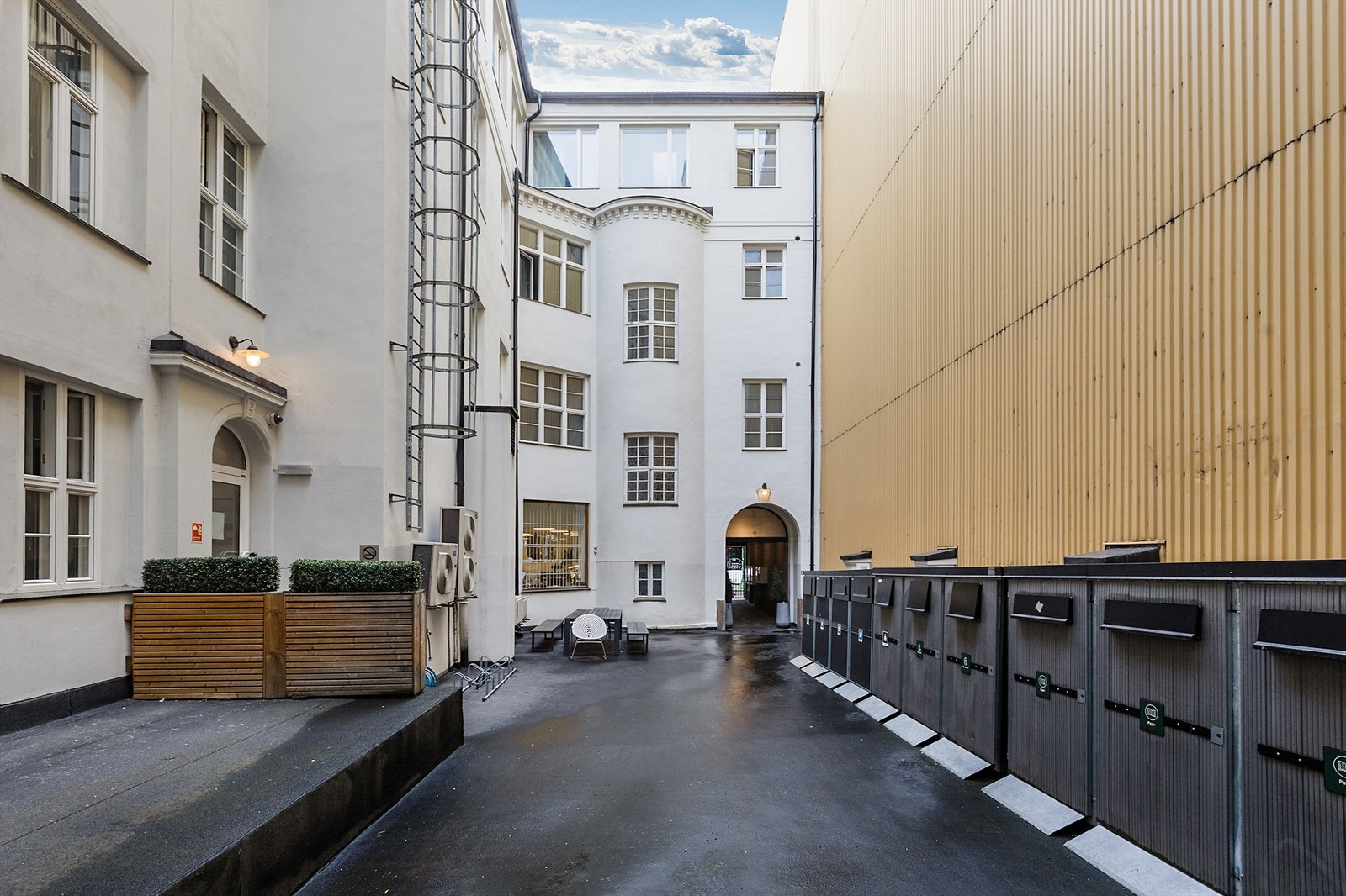 Fellesområde opparbeidet med asfalt, kildesortering, sittegrupper og sykkelparkering. Galleribilde