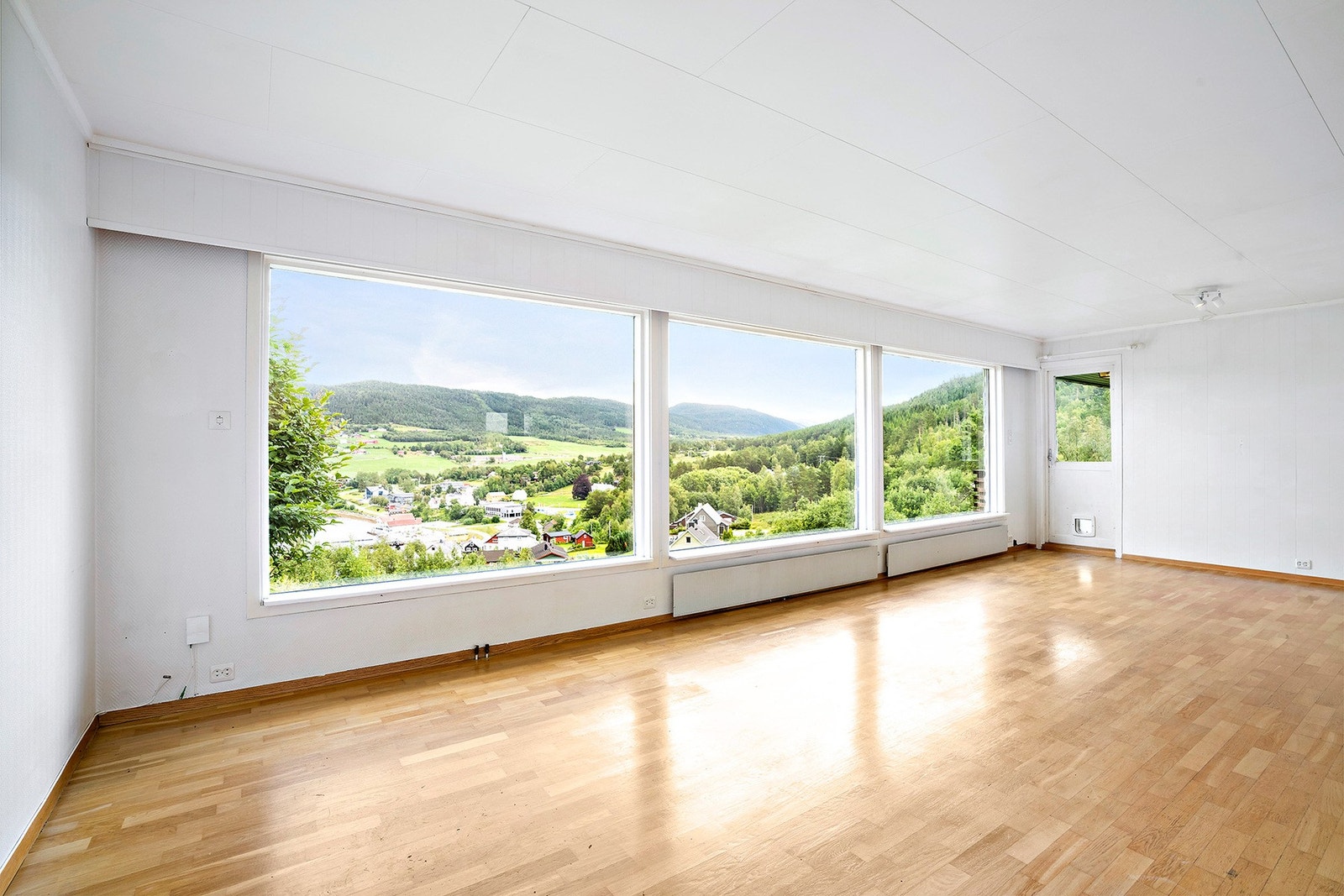 Stue med store vindusflater som slipper utsikten inn Galleribilde